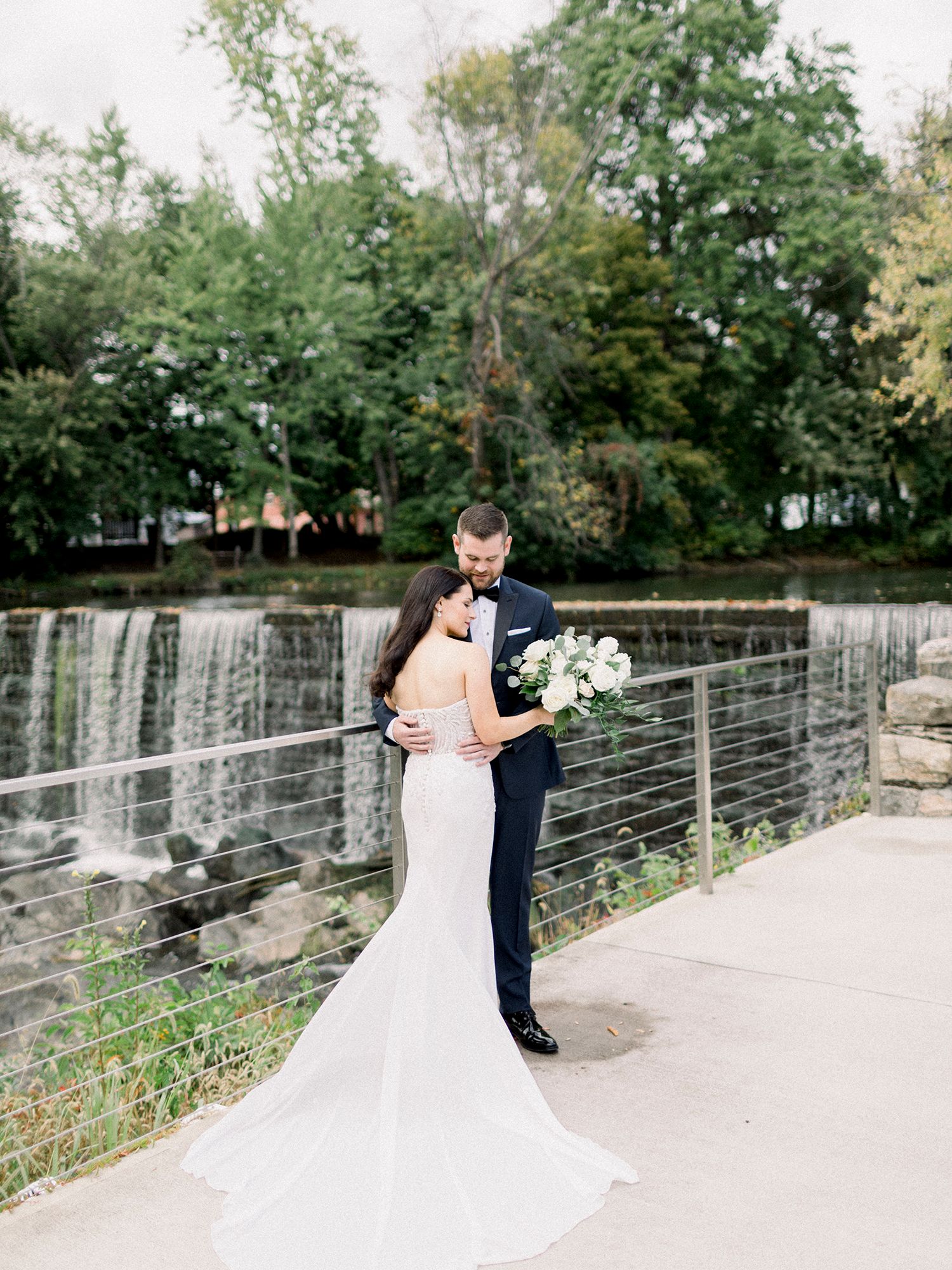 Romantic first look moment between couple on stone pathway with white wedding attire.