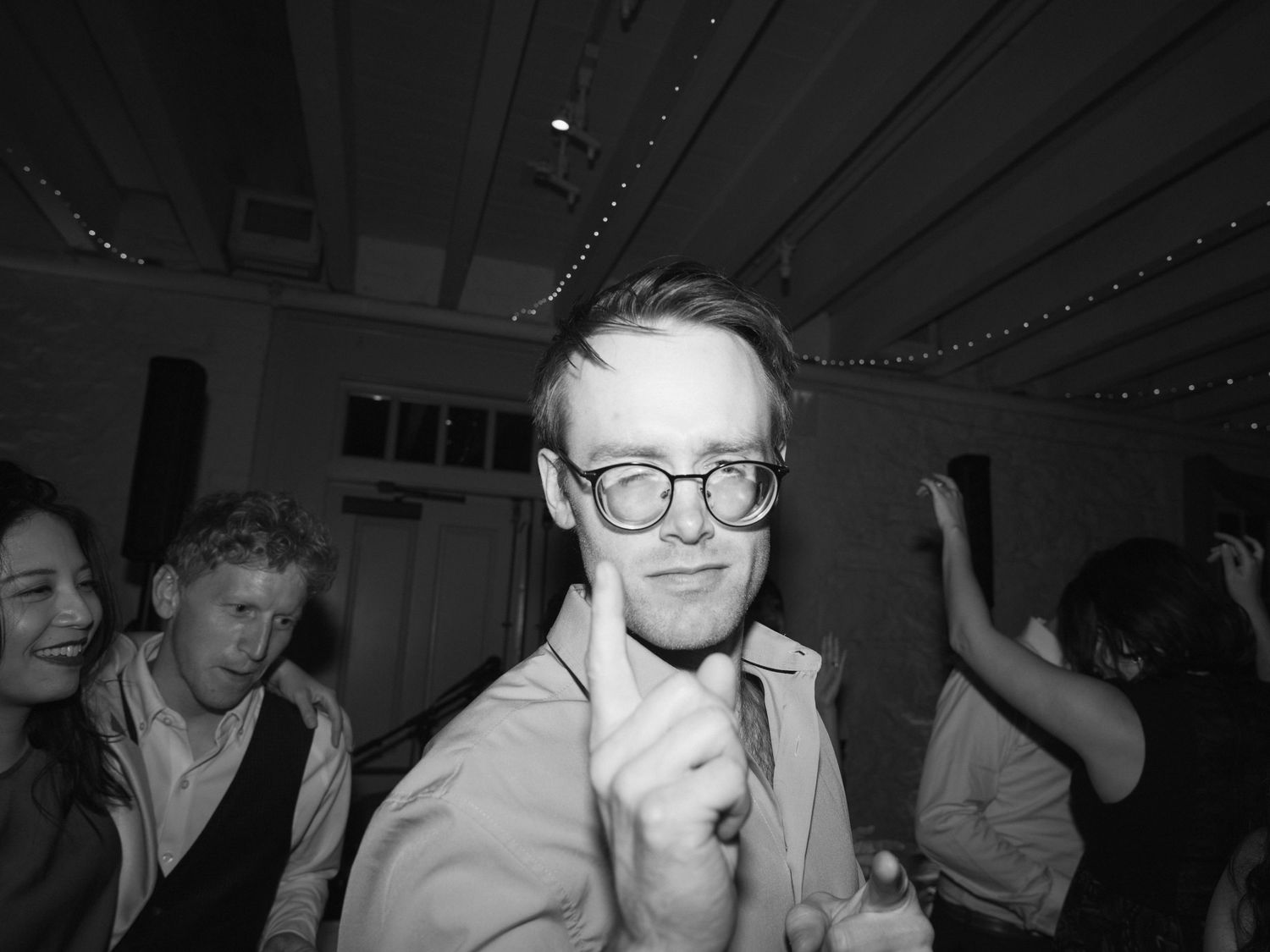 A party guest dances under dim lighting at an indoor celebration.