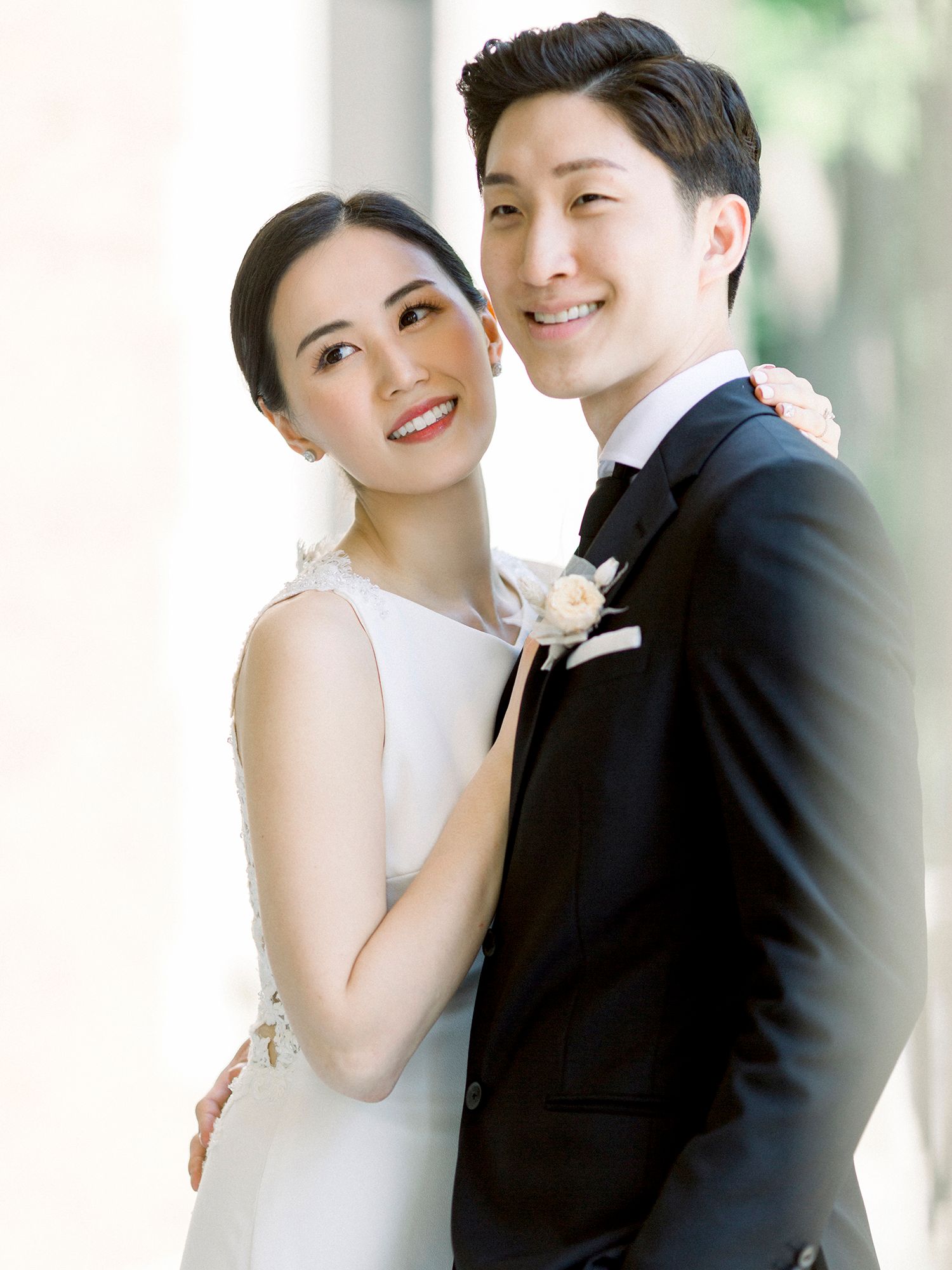 Intimate wedding portrait capturing joyful moment between couple in classic attire.