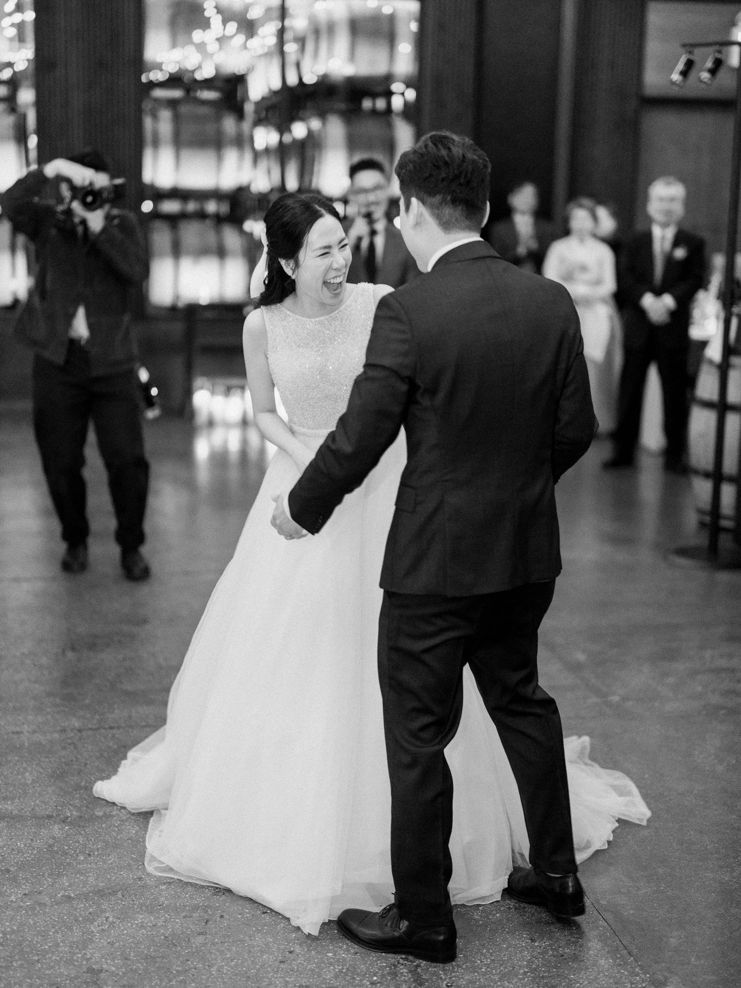 Wedding couple dancing together on a dark polished floor.