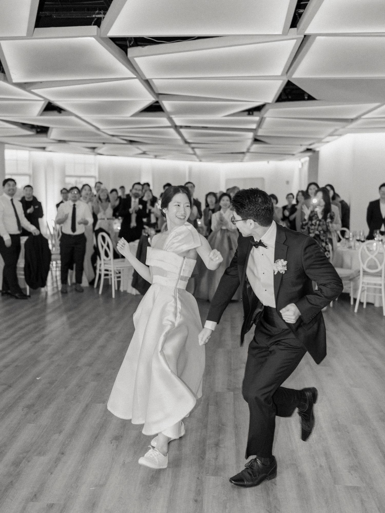Wedding reception dance floor filled with guests celebrating in a modern indoor venue.