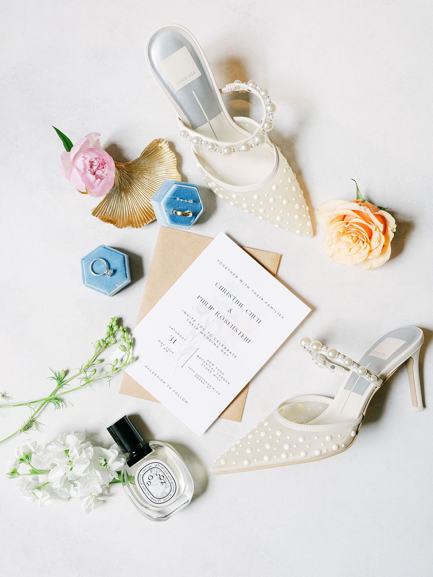 Wedding flat lay with invitations, flowers, jewelry and delicate accessories on white background.
