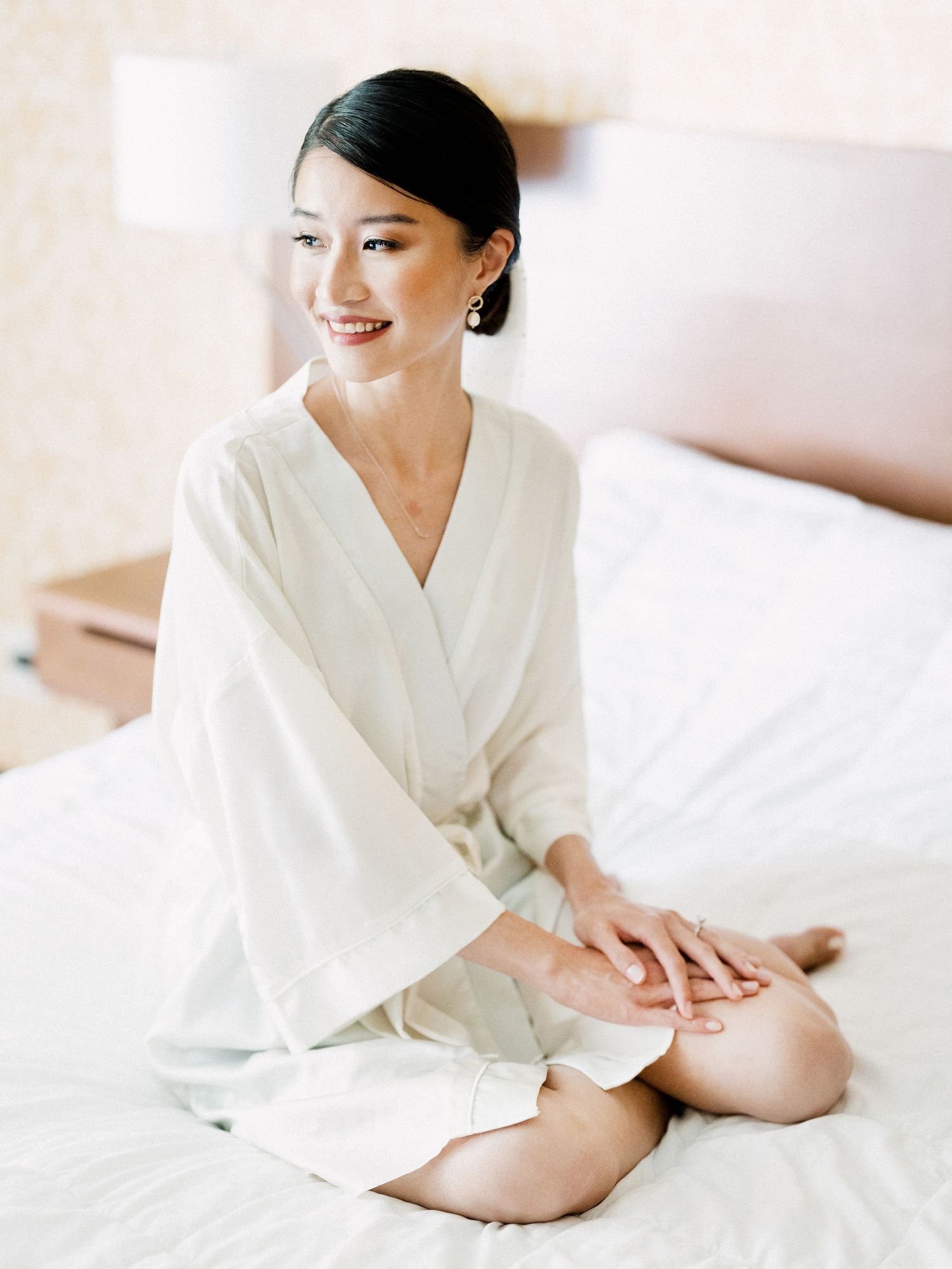 Serene morning preparation scene with white silk robe on soft bedding.