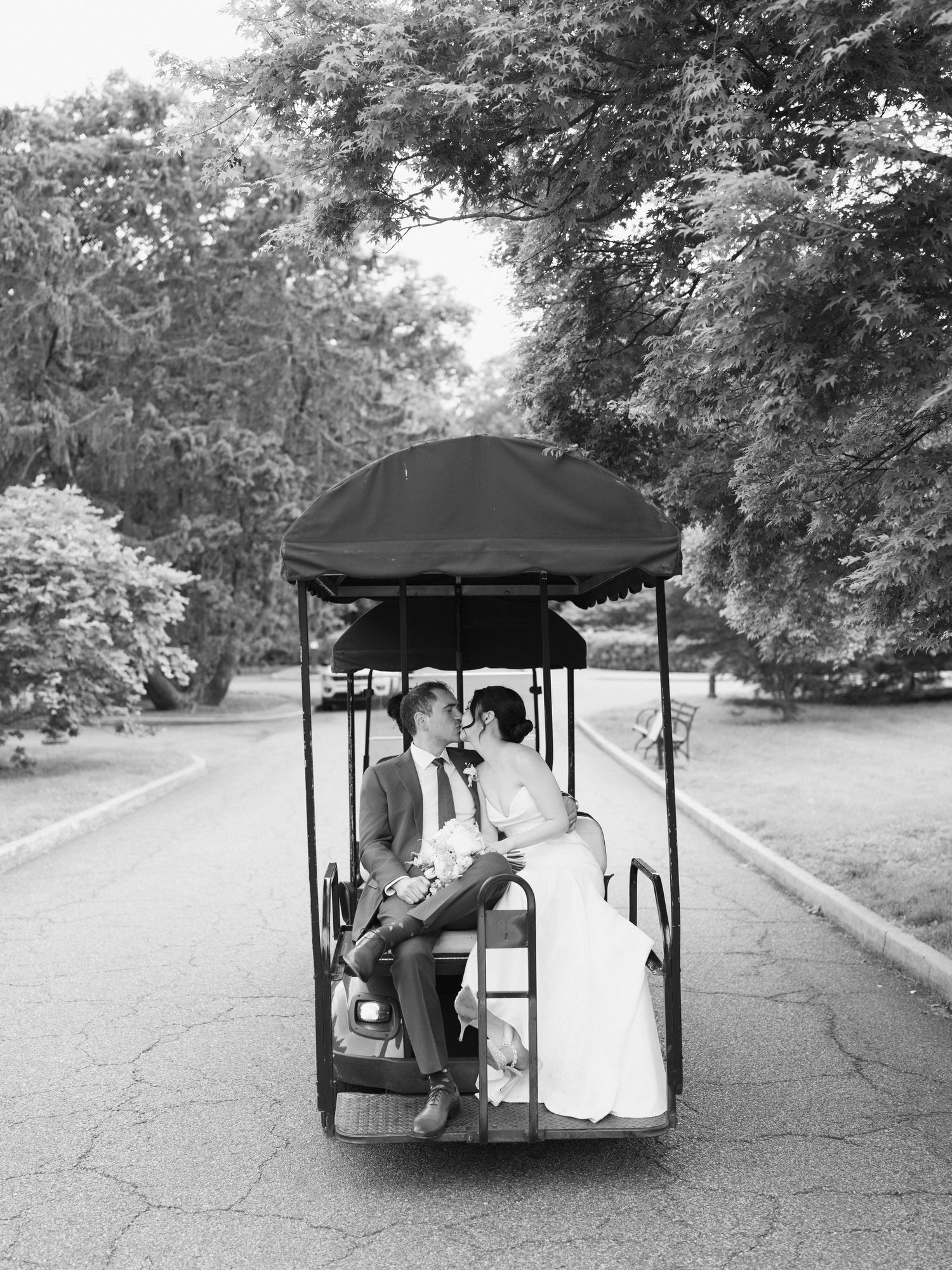 A couple shares an intimate moment while riding in a covered golf cart.