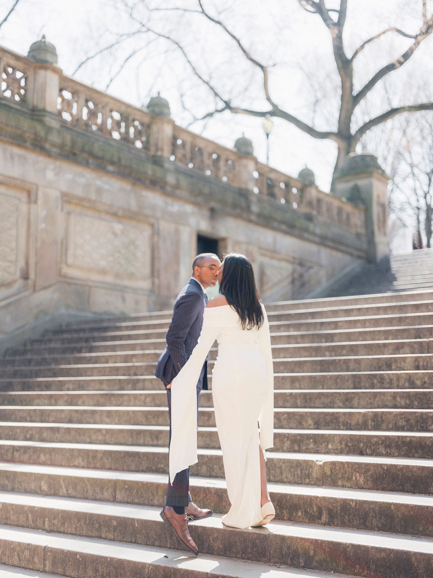Romantic moment captured on historic stone steps during an engagement photoshoot. Central park, NYC wedding photographer.