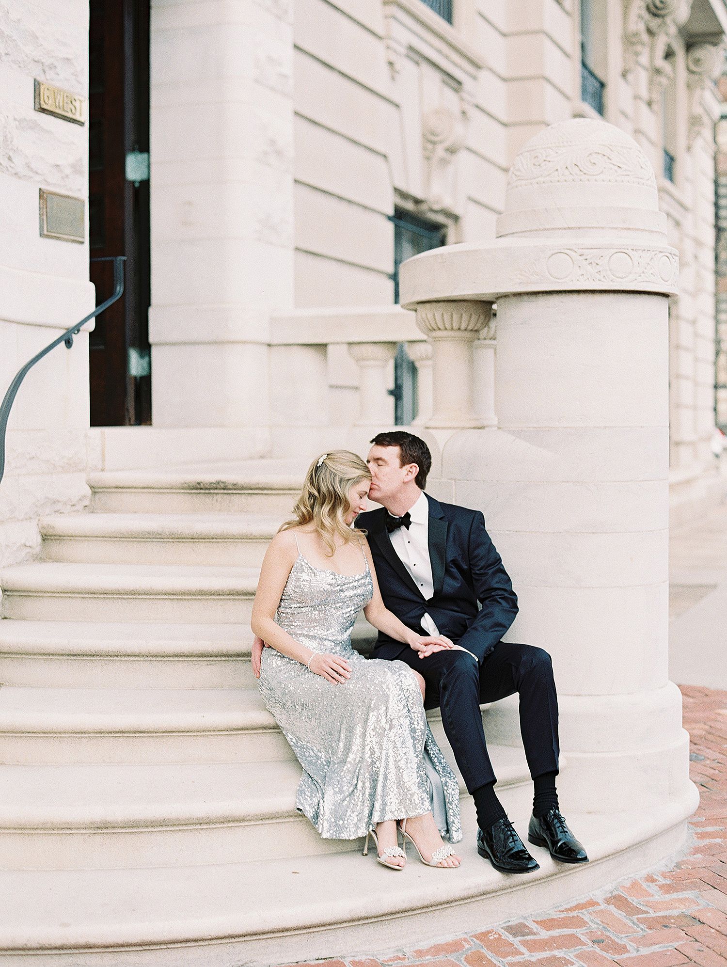 Wedding couple sharing intimate moments on classic white stone steps. NYC wedding photographer.