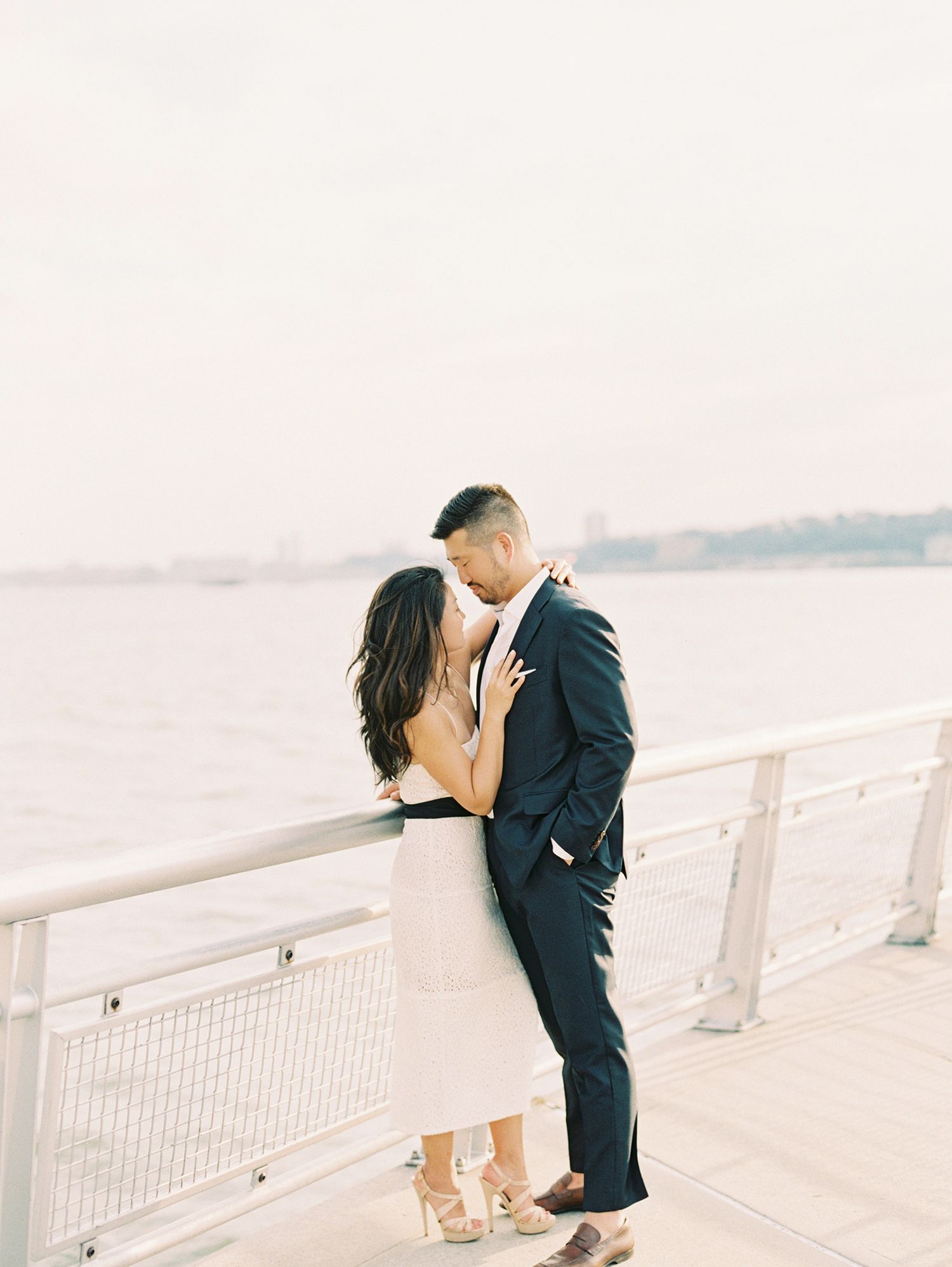 A romantic waterfront moment at sunset on a pier.