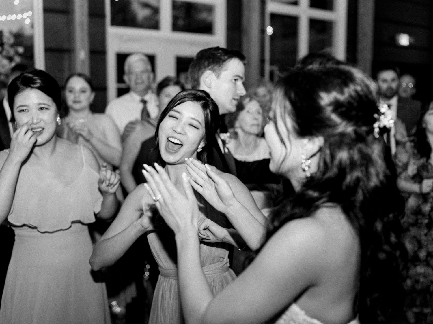 Wedding guests dancing and celebrating together in a reception hall.