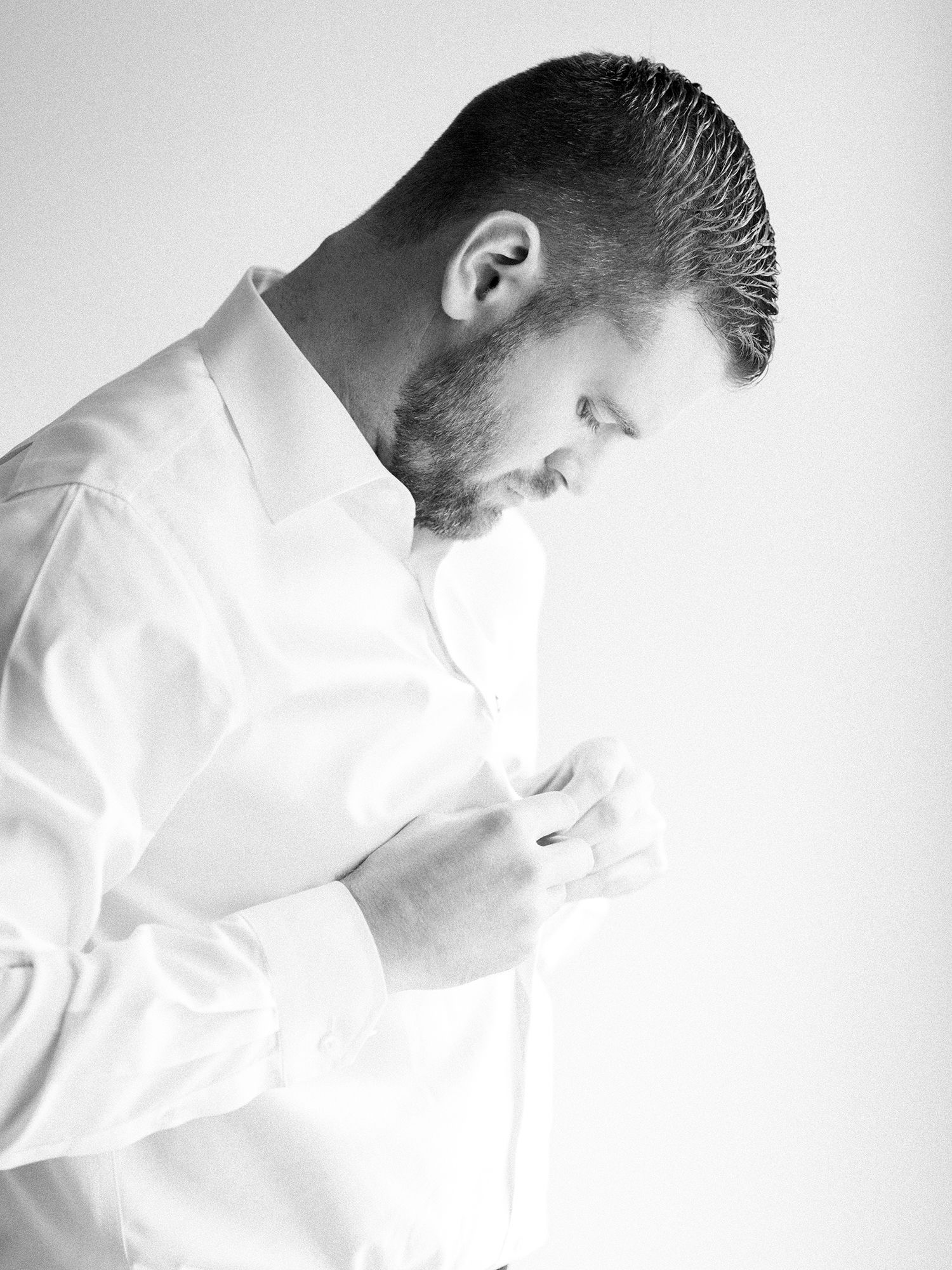 Minimalist black and white portrait showing profile in soft light.