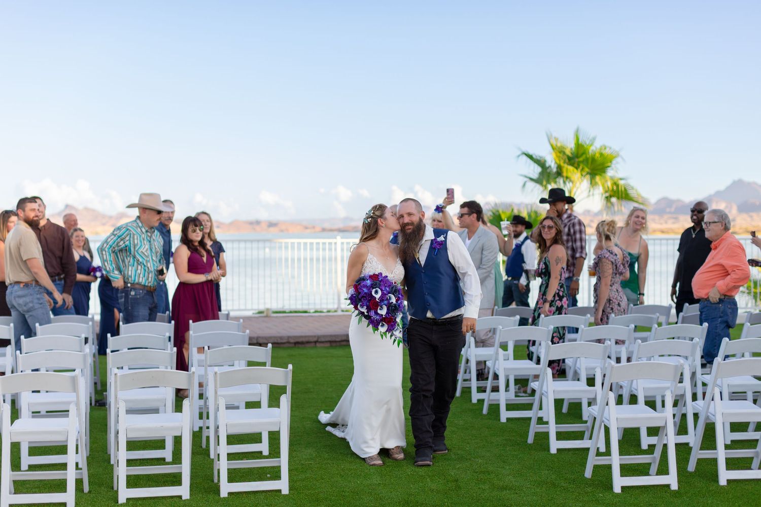 White chairs arranged in rows on a green lawn for an outdoor wedding ceremony at the Nautical Lake Havasu