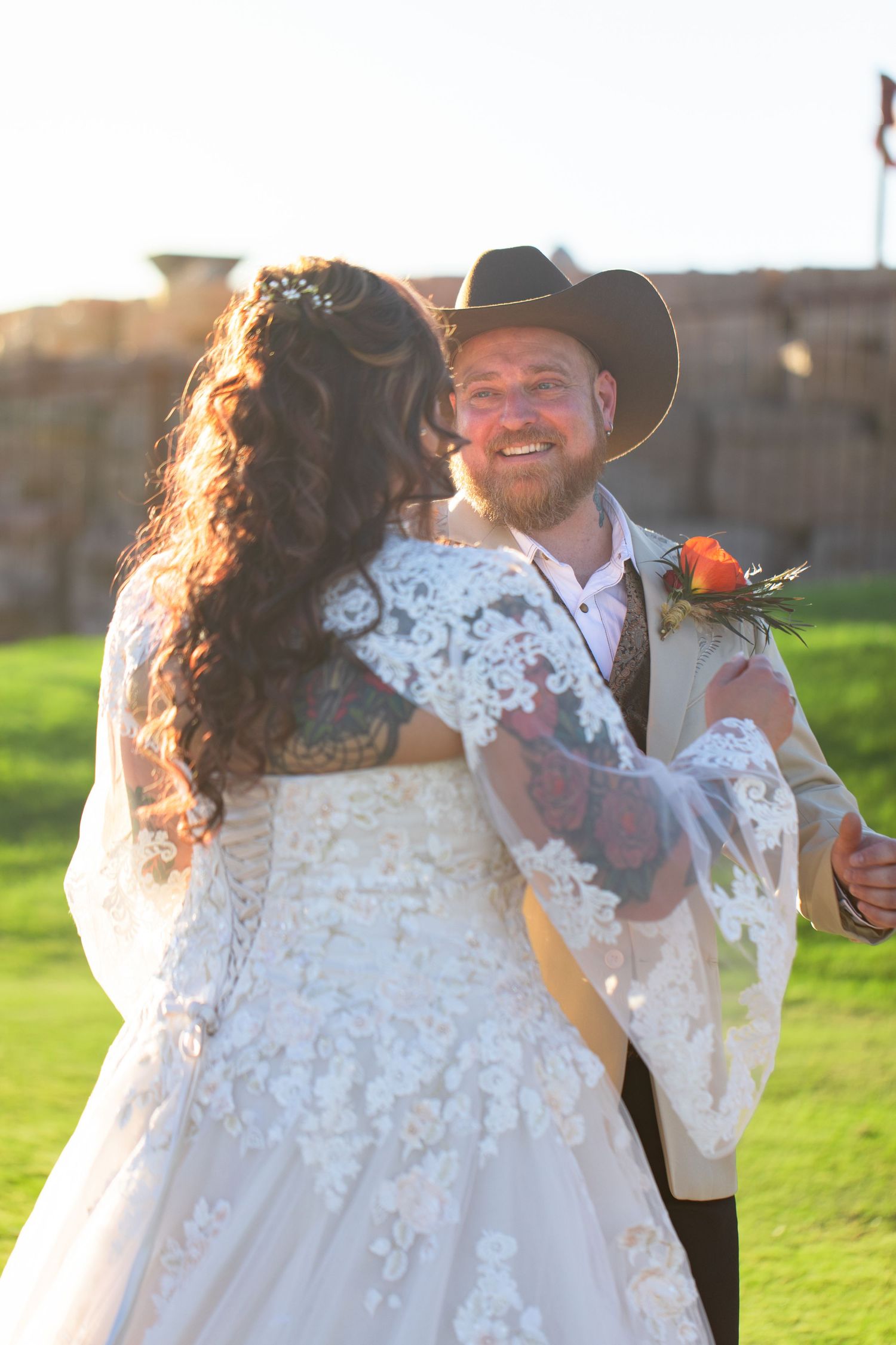 A romantic outdoor wedding scene with a couple dancing in golden sunlight on a grassy lawn at iron wolf lake havasu city