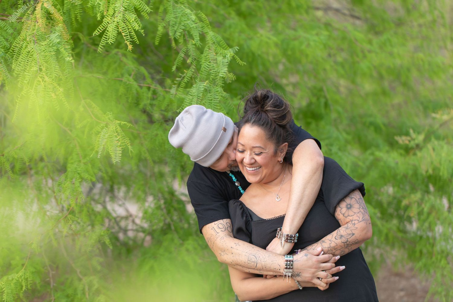 Candid couple portraits taken outdoors at rotary park lake havasu with natural greenery in background.