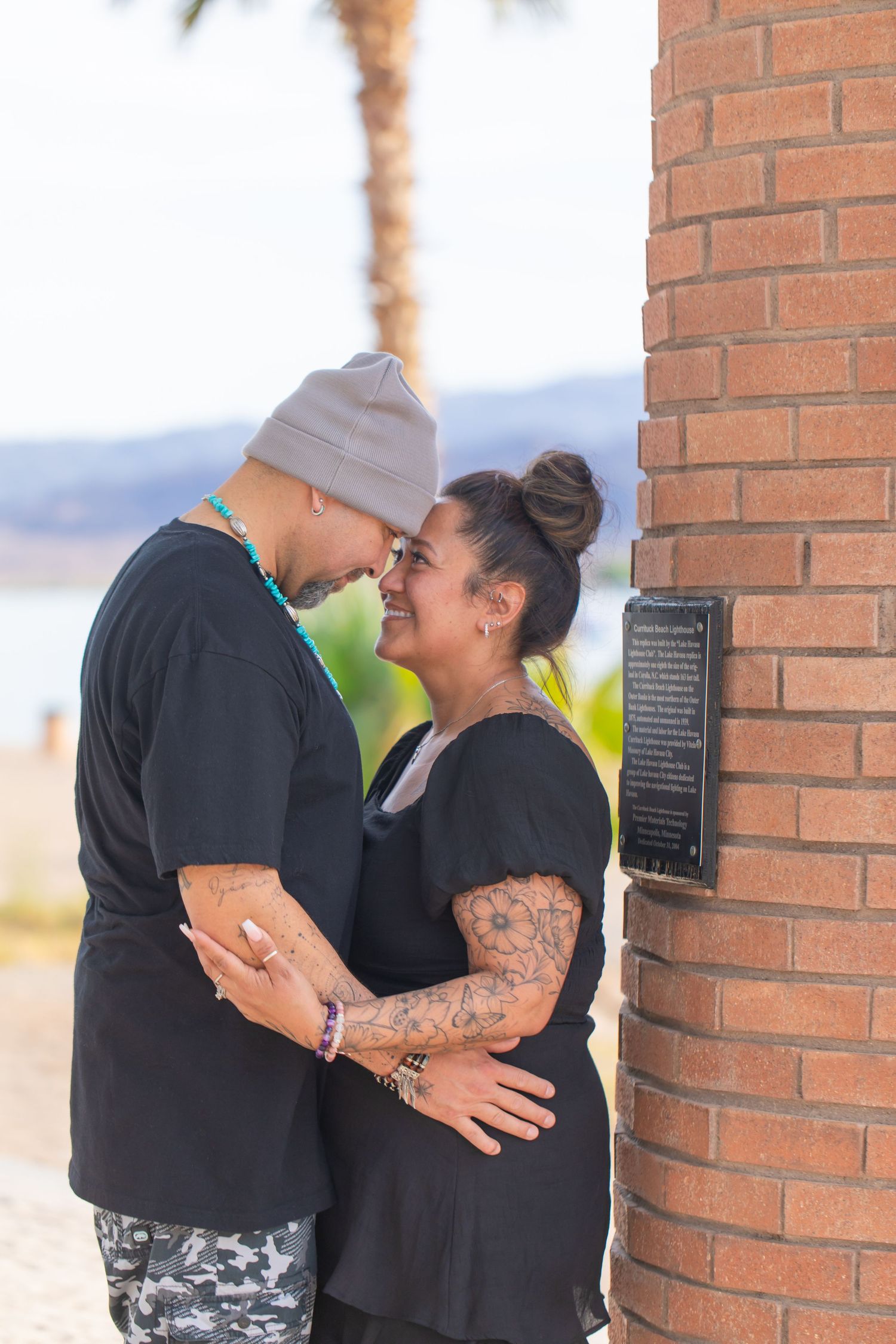 Couple sharing an intimate moment against a brick lighthouse at the bridgewater channel in lake havasu city arizona.