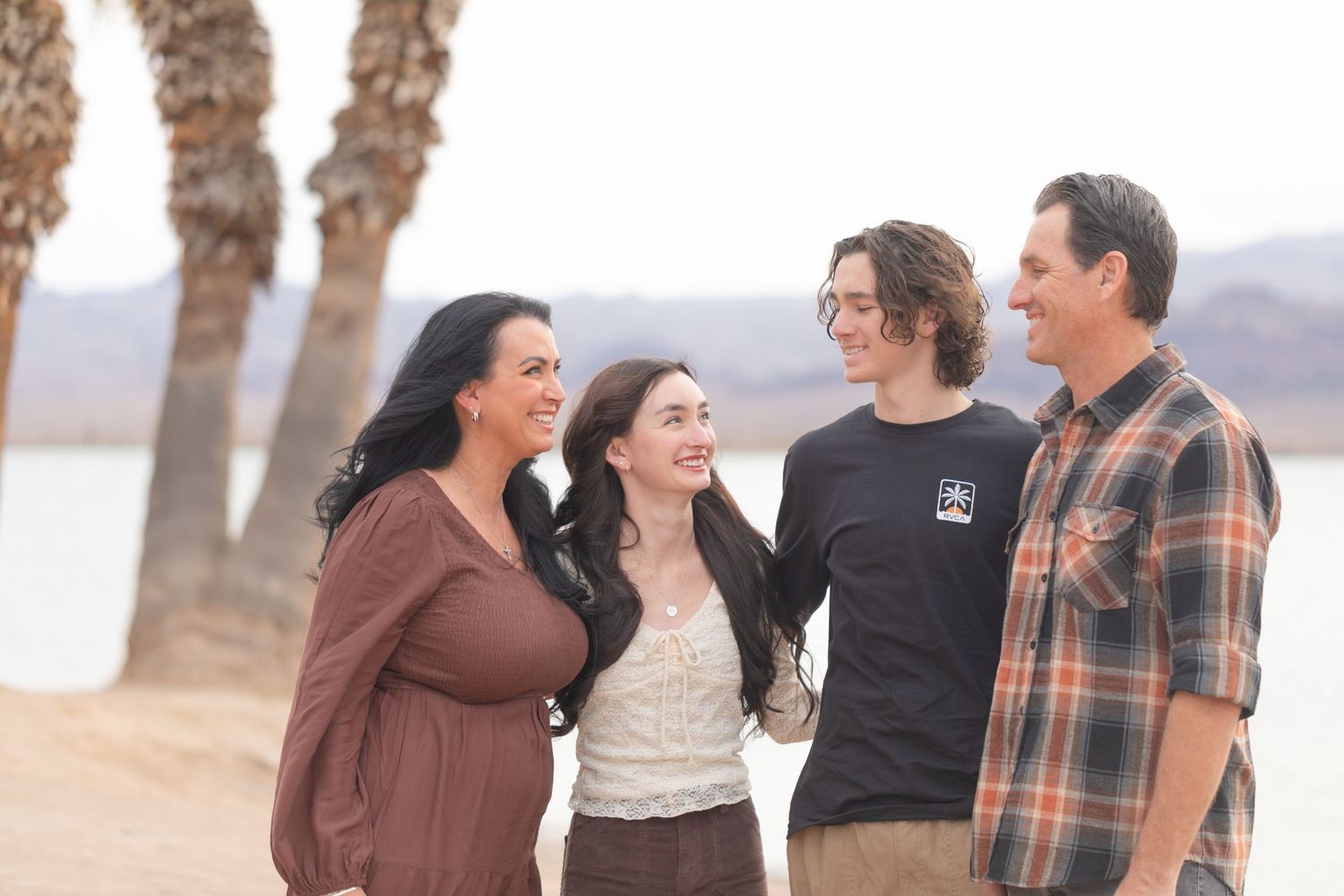 Friends gathered for casual outdoor photos in earth-toned clothing at rotary park beach lake havasu