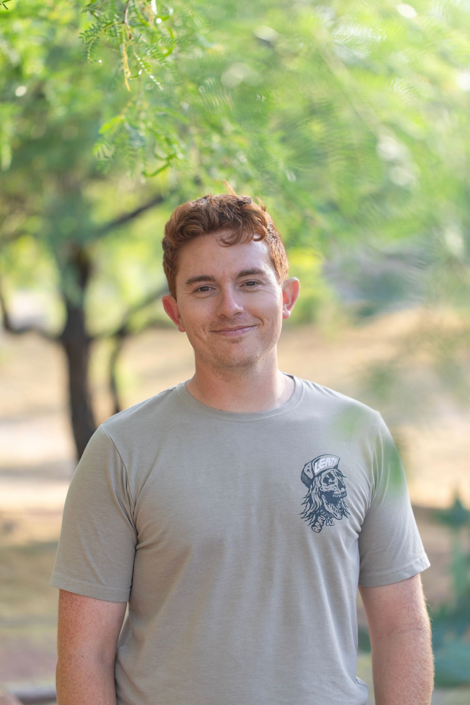 Casual outdoor portrait session in a leafy green park setting.