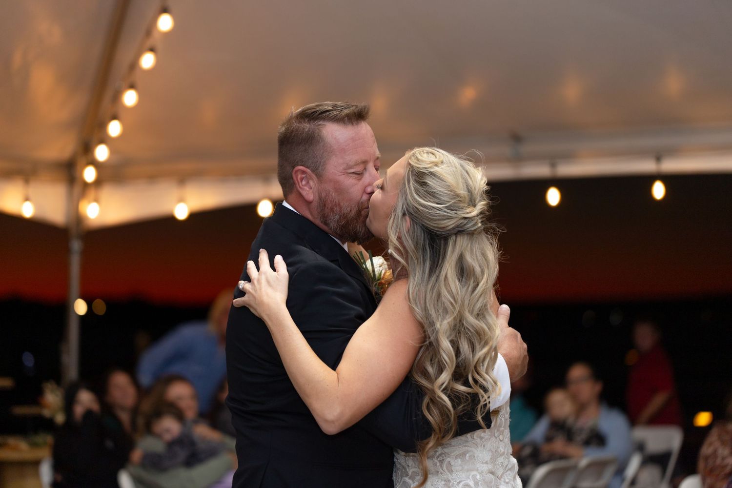Couple's first dance at wedding reception under warm lighting and string lights, Lake Havasu City.