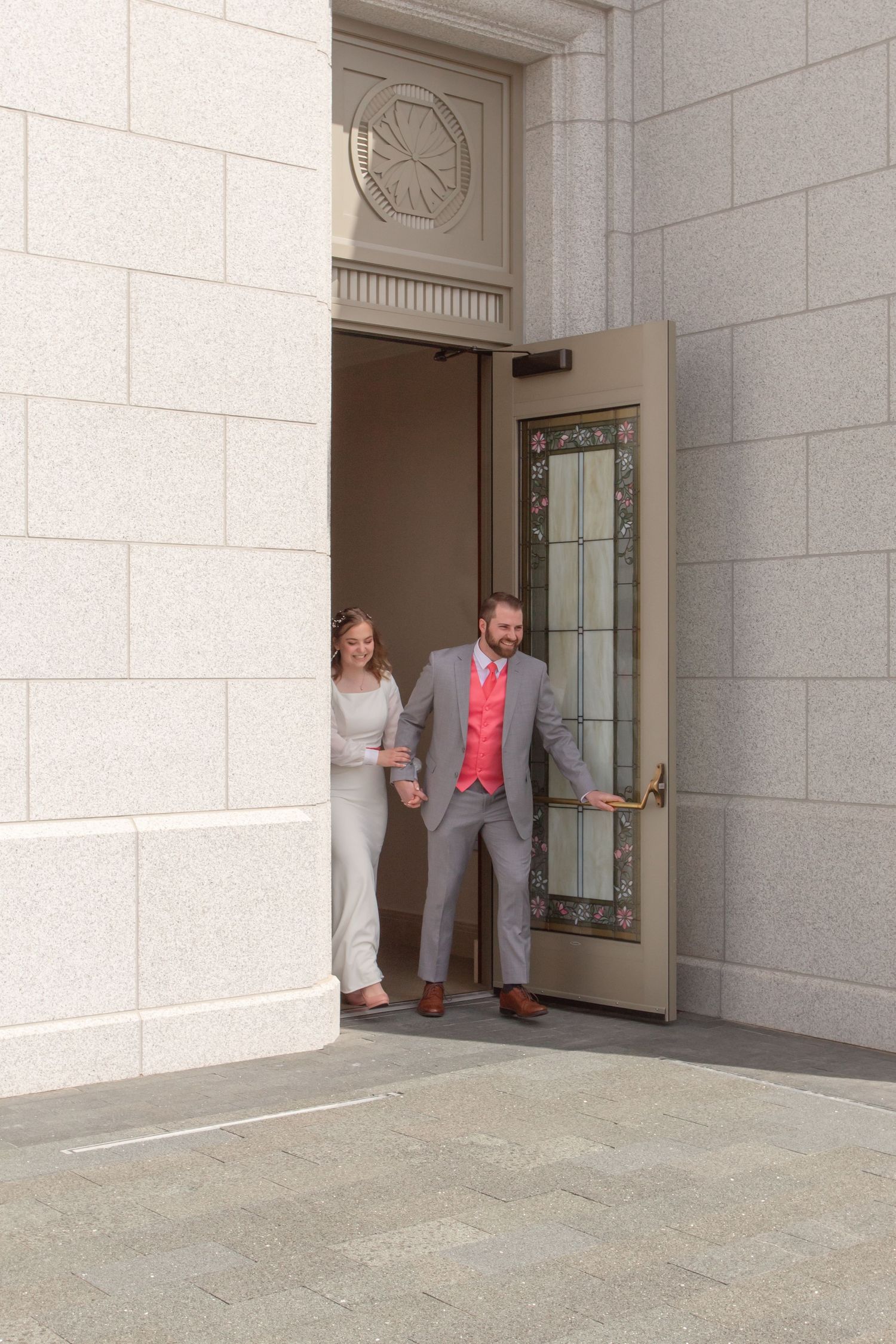 A sequence showing people peeking out from behind a white stone building doorway.
