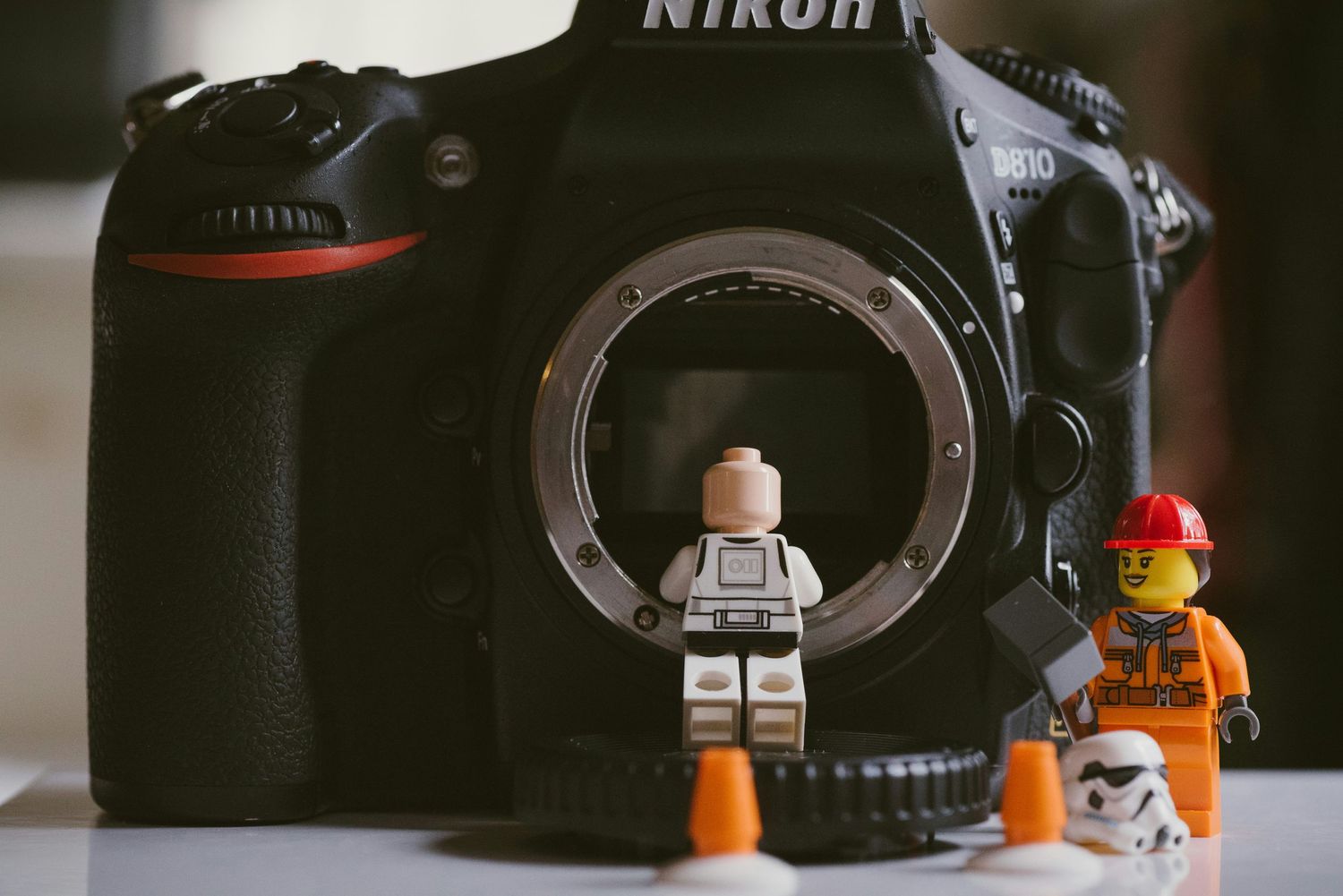 Creative Nikon DSLR camera setup with LEGO minifigures posed around lens mount.
