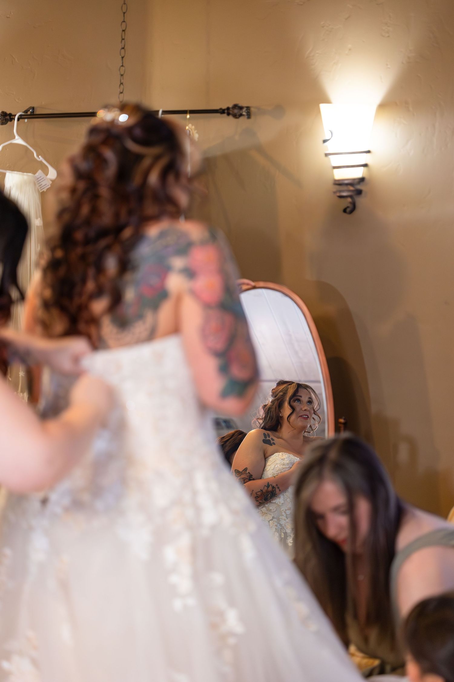 Wedding dress preparation scene reflected in mirror with hanging garments and warm lighting at iron wolf lake havasu