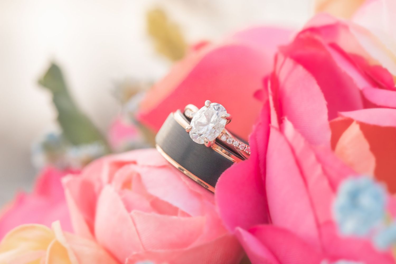 Diamond engagement ring nestled among pink rose petals with soft focus. shot by lake havasu wedding photographer arianna hosea