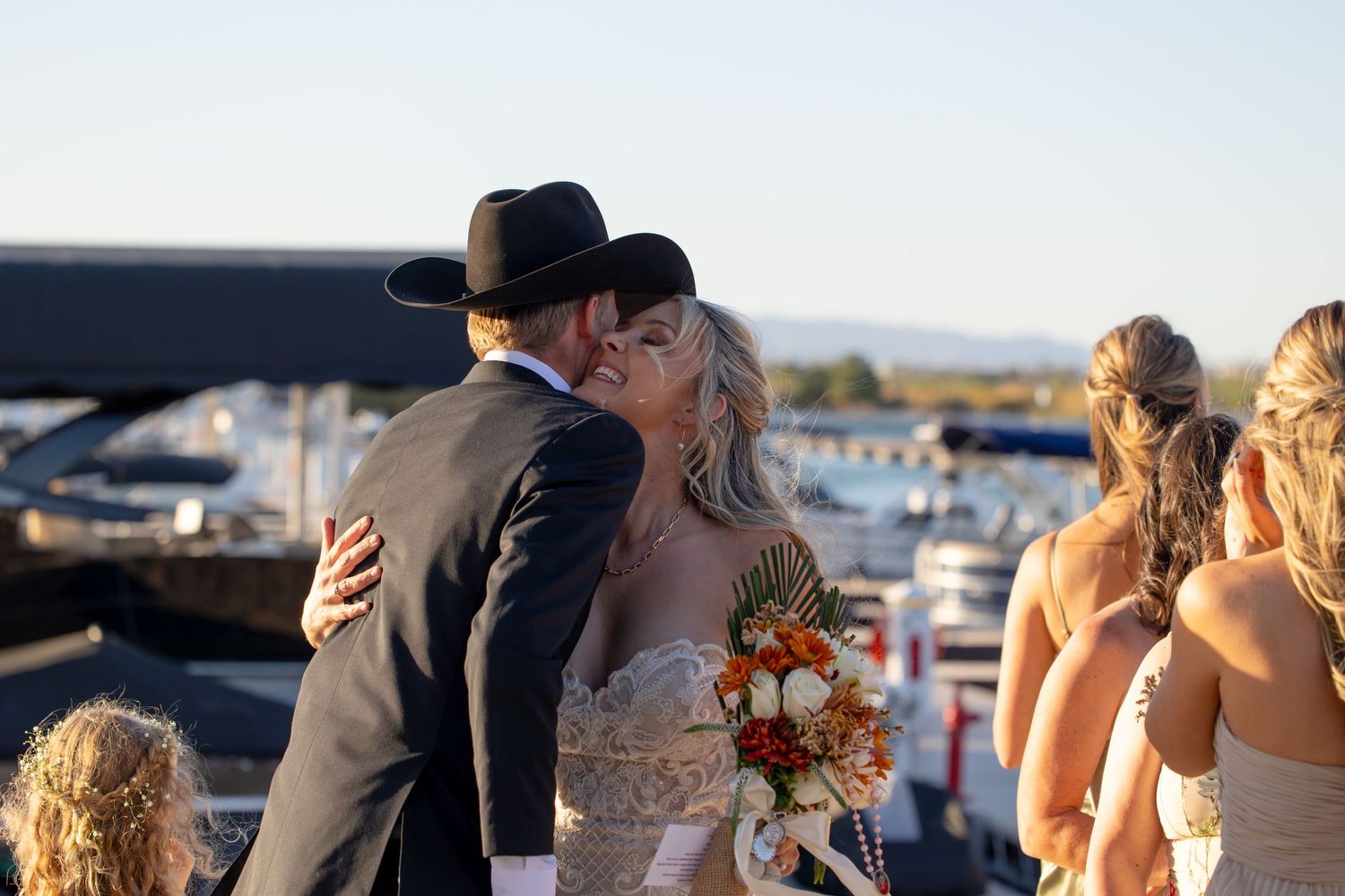 Sunset wedding ceremony taking place on a dock with boats and water in the background in Lake Havasu City Arizona