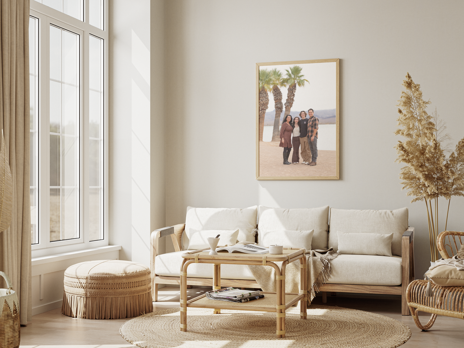 A bright modern living room with white sofa, rattan furniture and framed artwork on the wall.