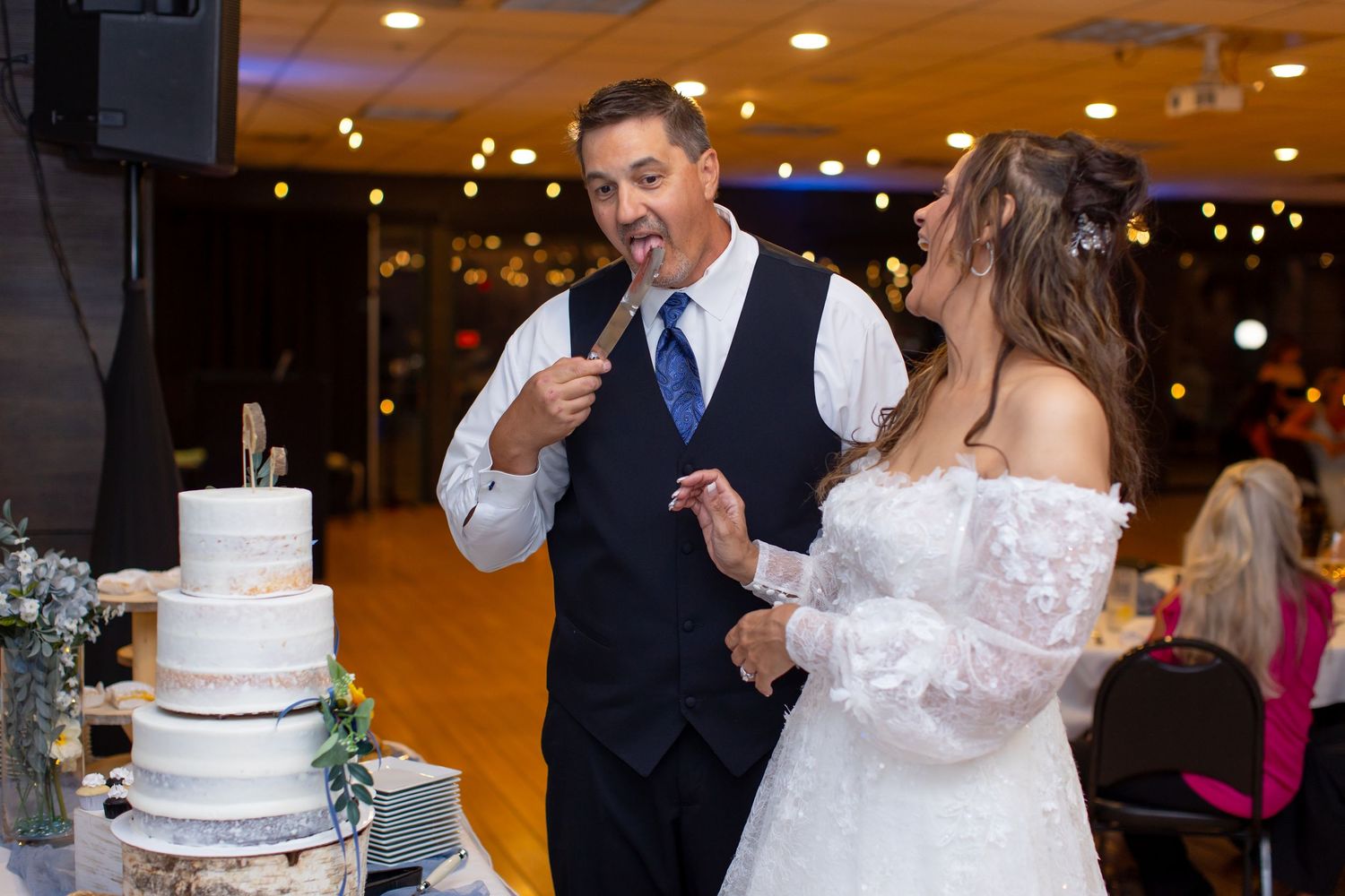 Bride and groom laughing together during wedding cake cutting ceremony at Shugrues in Lake Havasu City Arizona