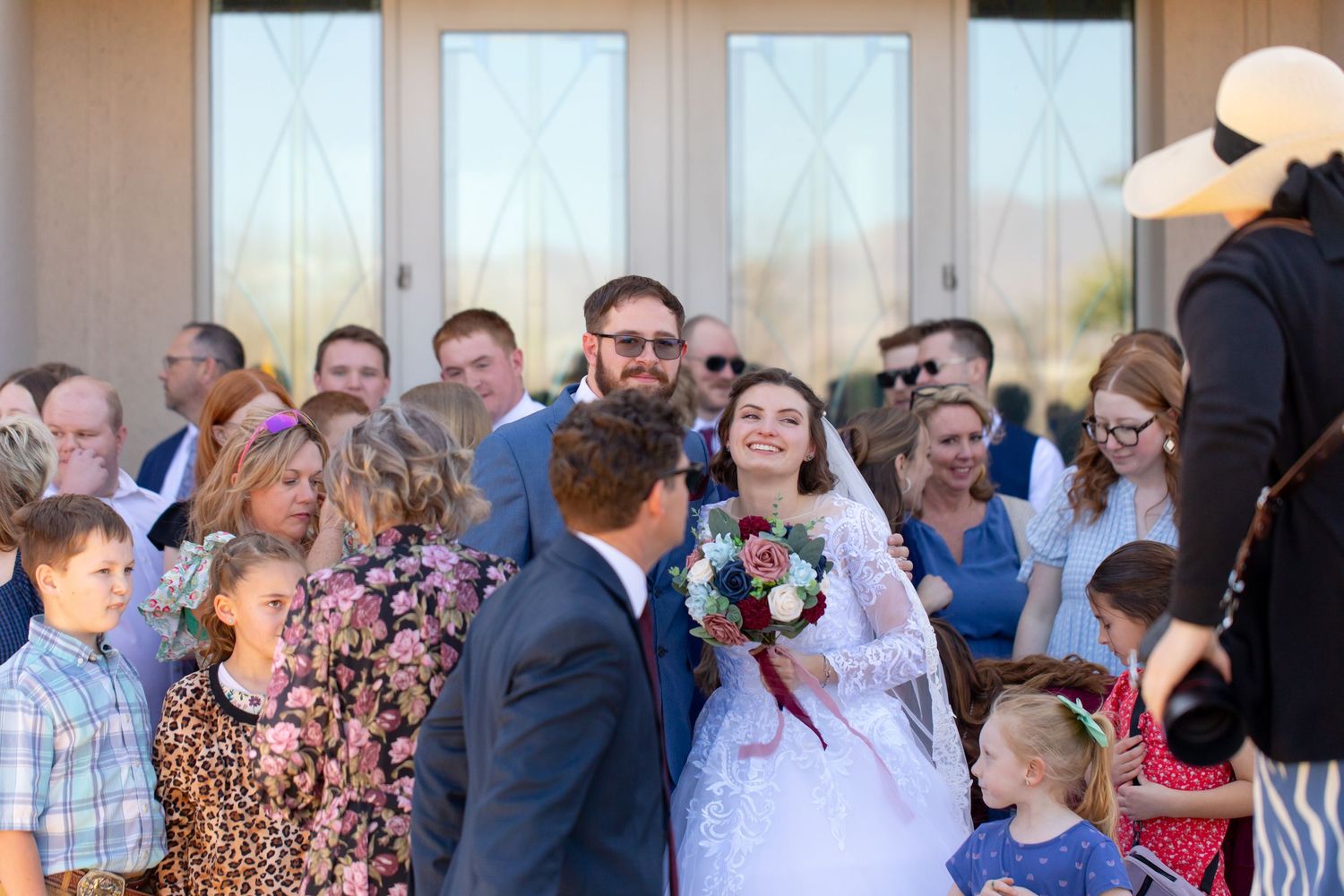 Wedding guests dance and socialize at an evening reception in an elegant indoor venue.