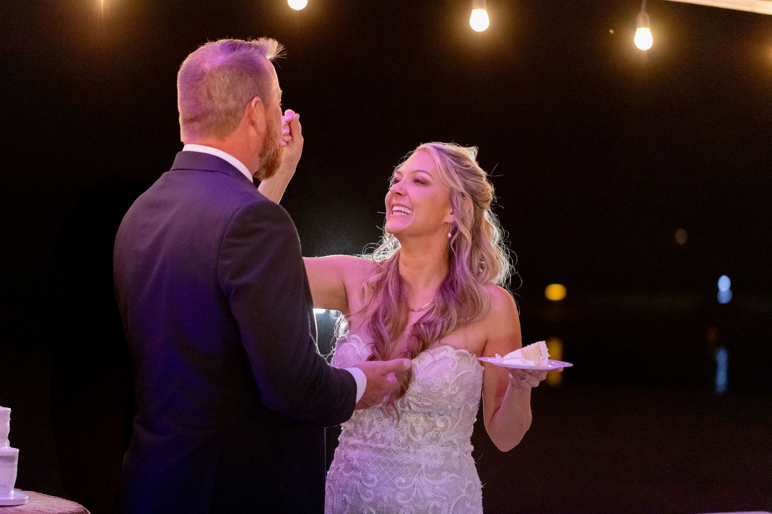 Newlyweds sharing a sweet cake moment at their Lake Havasu wedding reception at The Riviera Marina.