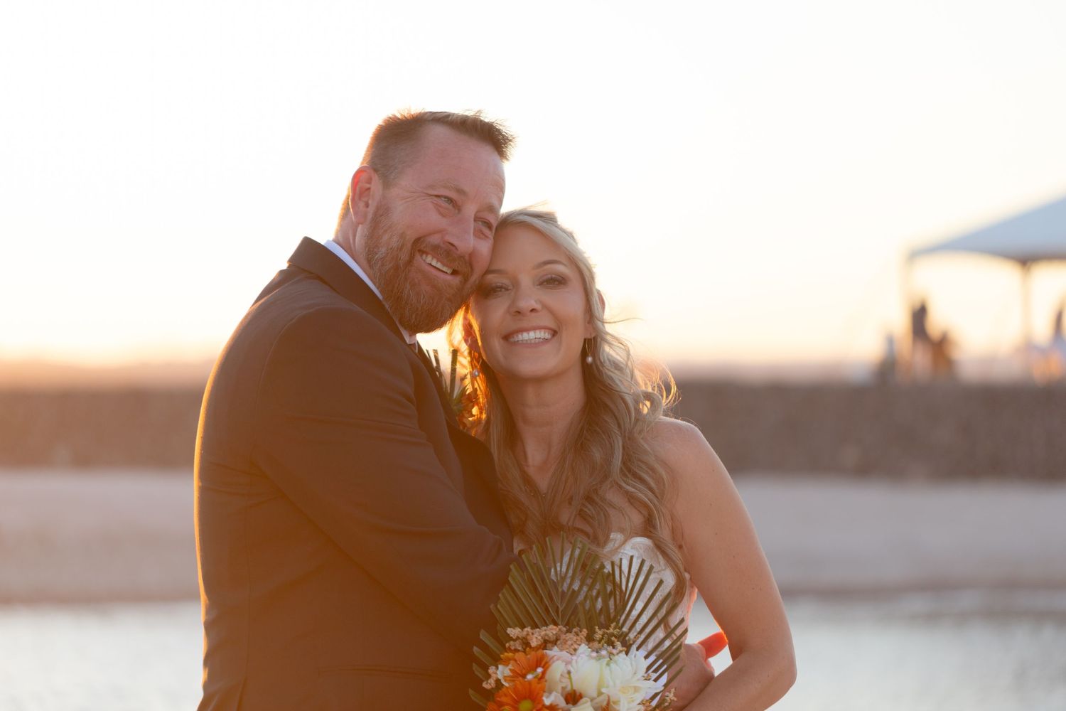 oyful couple sharing intimate moment at sunset during beach wedding ceremony in Lake Havasu City.