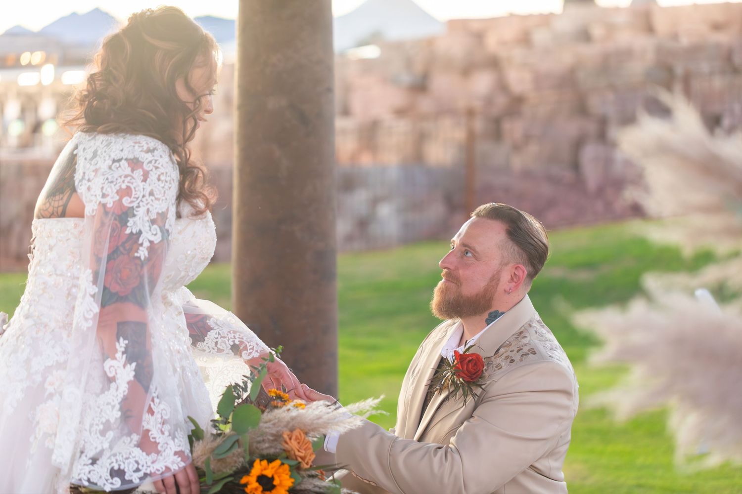 Newlyweds at Iron Wolf lake havasu az shares tender moments between stone pillars with mountain landscape in background