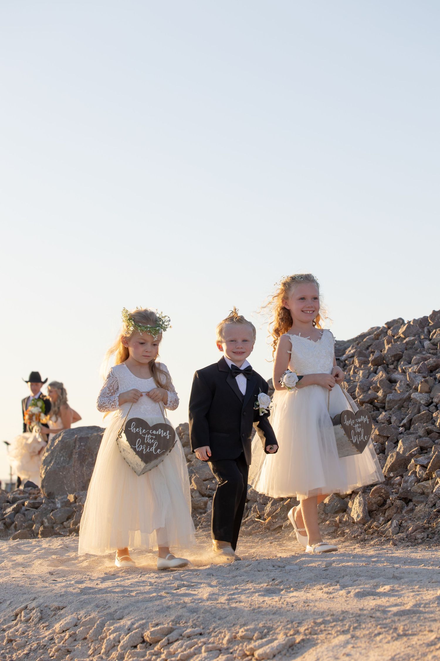 Flower girls and ring bearer walking together on a rocky path at sunset in Lake Havasu City Arizona at the Riviera Marina