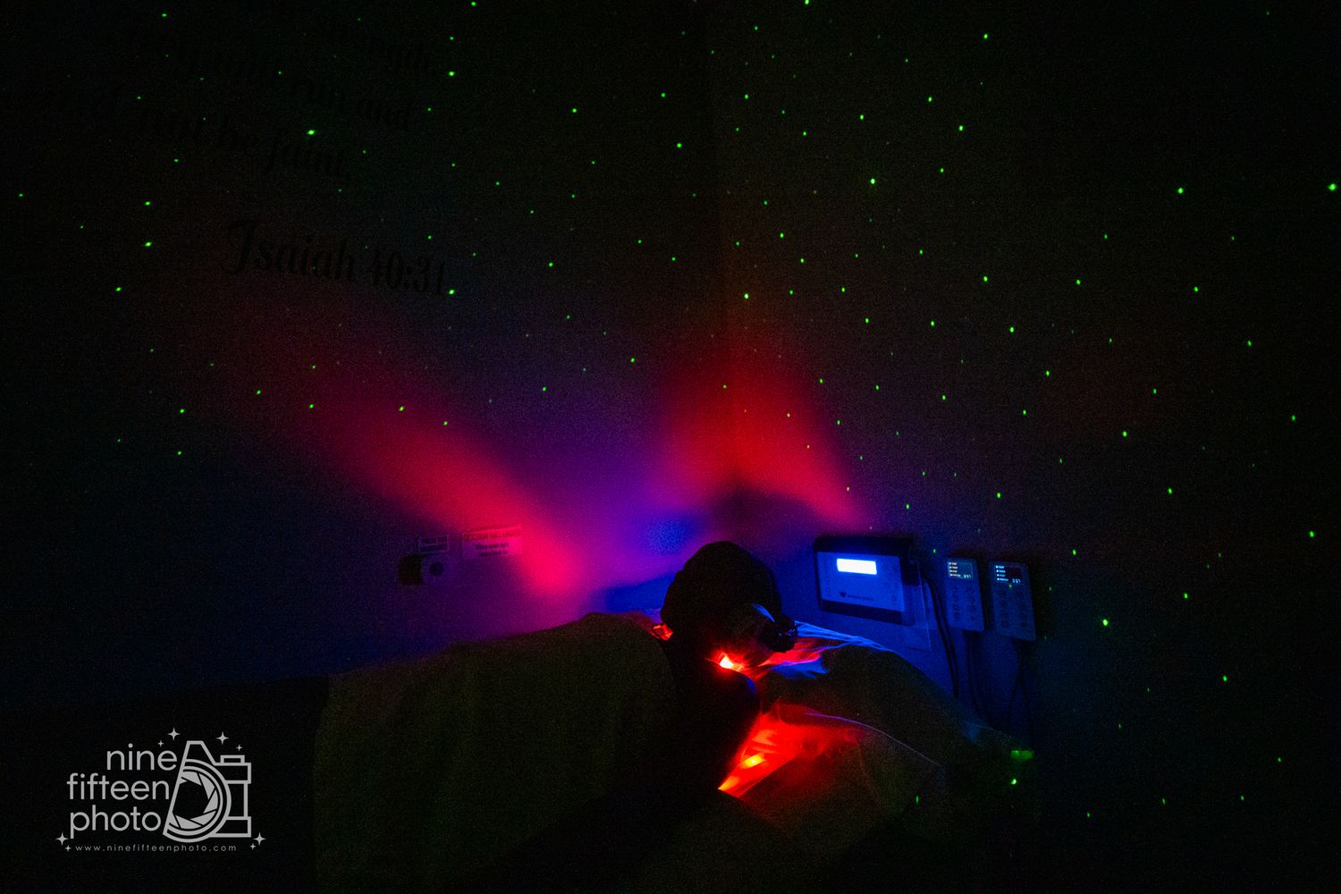 Photographer capturing a stunning night sky with colorful red and blue light beams illuminating the darkness.