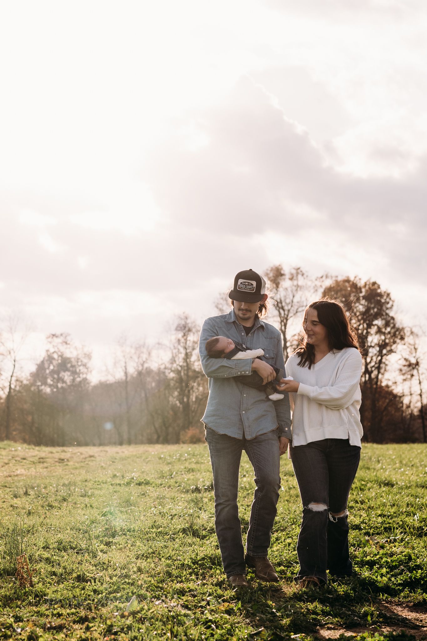 Custer KY newborn lifestyle photo of Kaylin and Caleb with their baby Devin, captured by ninefifteenphoto in rustic golden light.