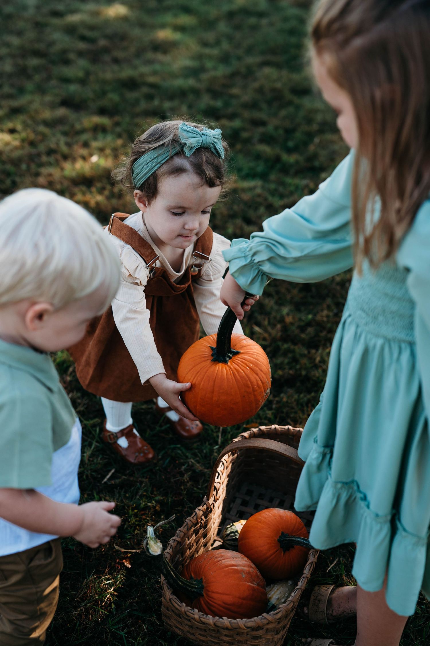 Children picking pumpkins during relaxed family photo session in Meade County KY.