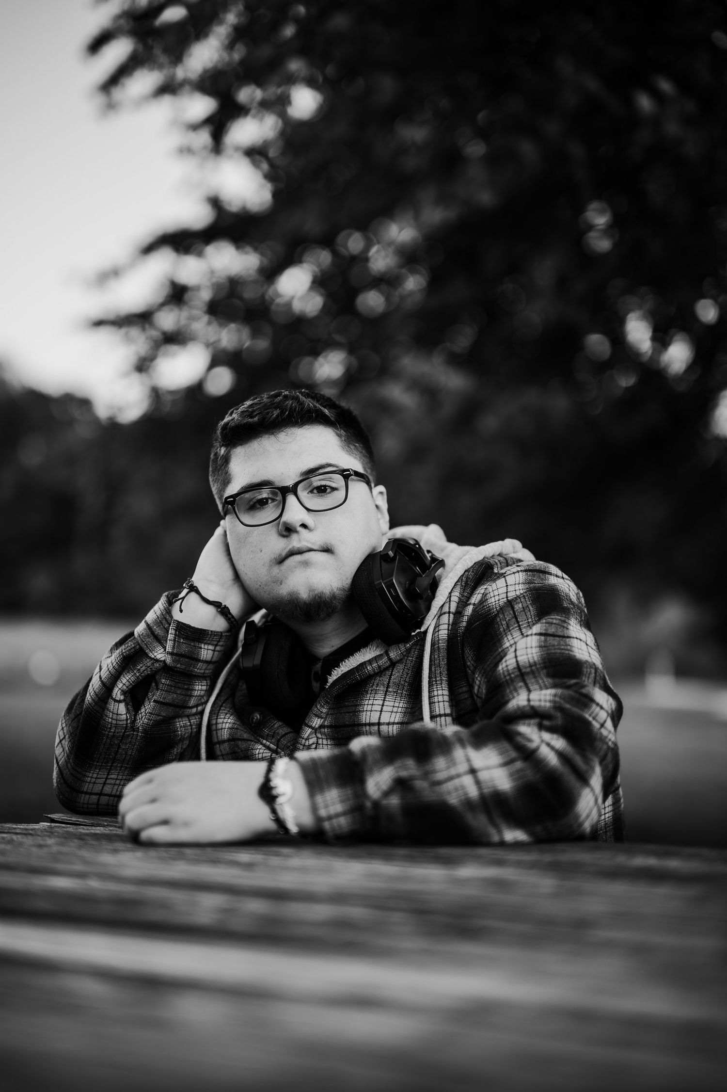 Black and white portrait of Luca leaning on a bench during his senior photo session in Brandenburg KY.