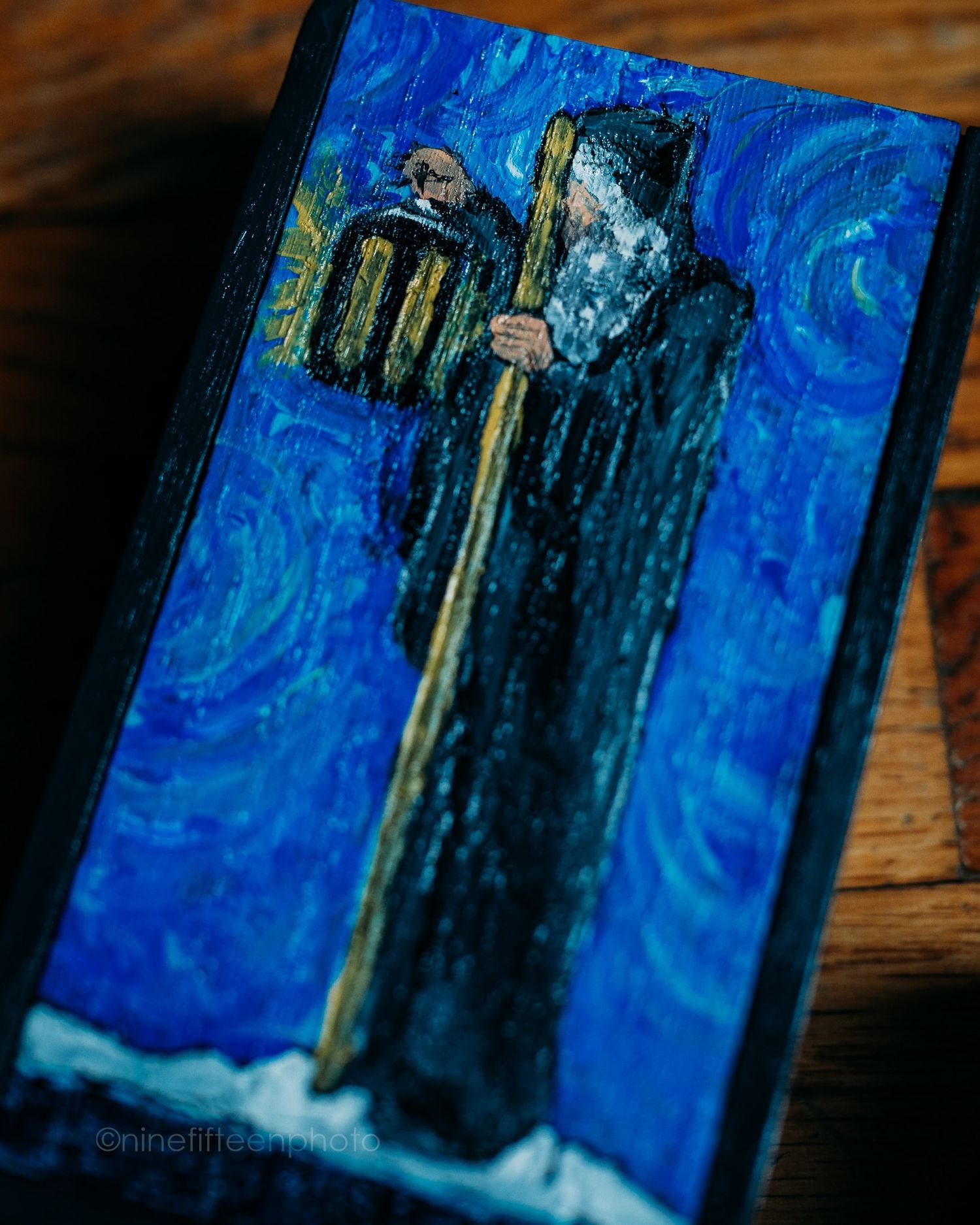 Detailed Van Gogh-inspired painting of a robed hermit figure with staff on deep blue swirling background.