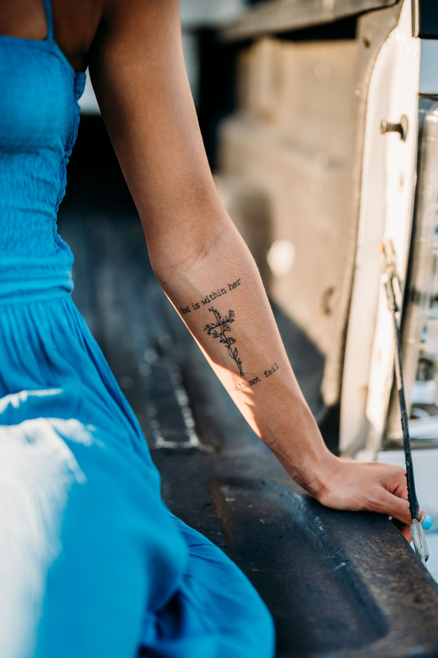 Close-up of Bella’s tattoo and blue dress during rustic senior photo session in Brandenburg KY by ninefifteenphoto