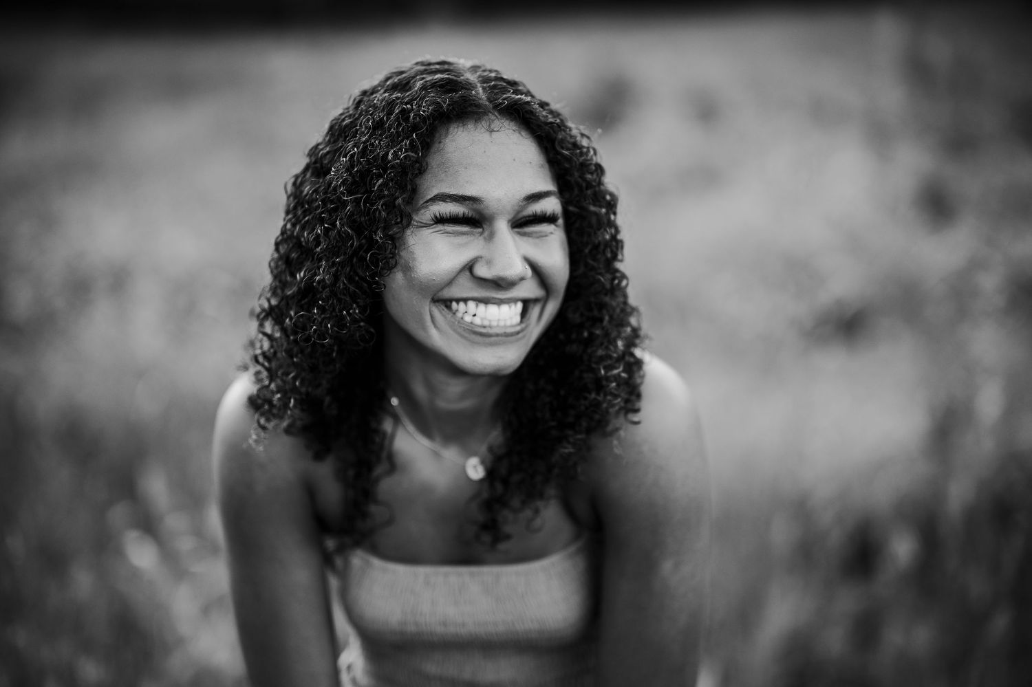 Candid black and white portrait of Bella smiling during outdoor senior photo session in Brandenburg KY