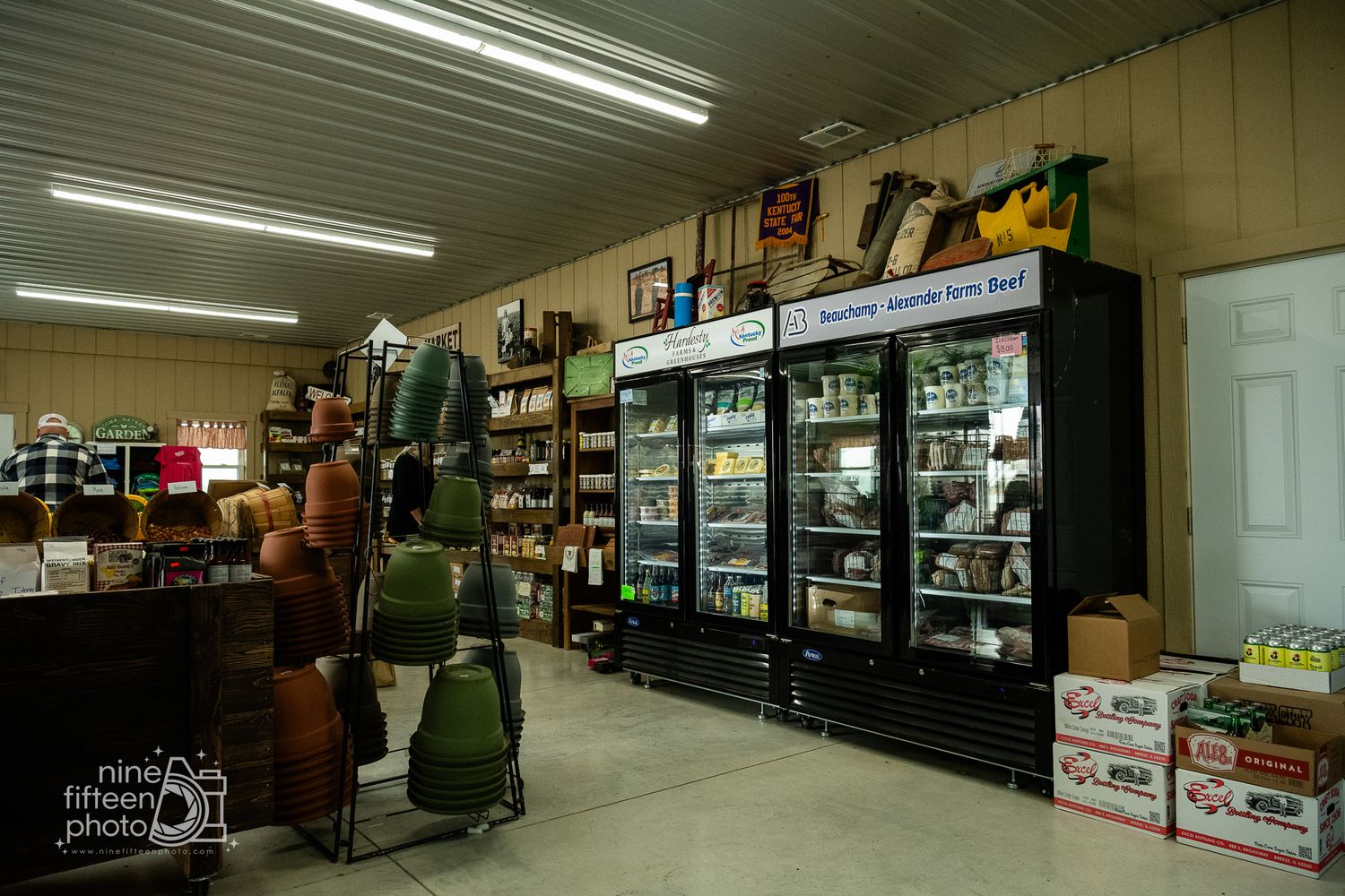 Interior of a farm market store with refrigerated display cases stocked with local products.