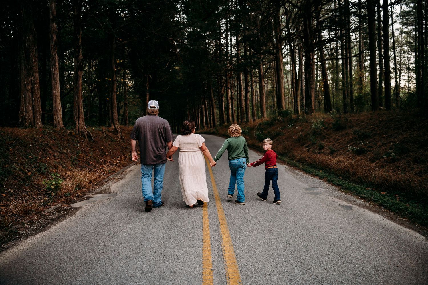 Family walking down road surrounded by trees during Brandenburg fall photo session