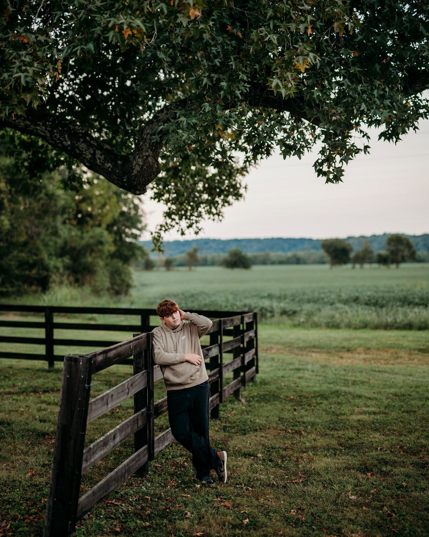 senior leaning against the fence during his sesison with ninefifteenphoto