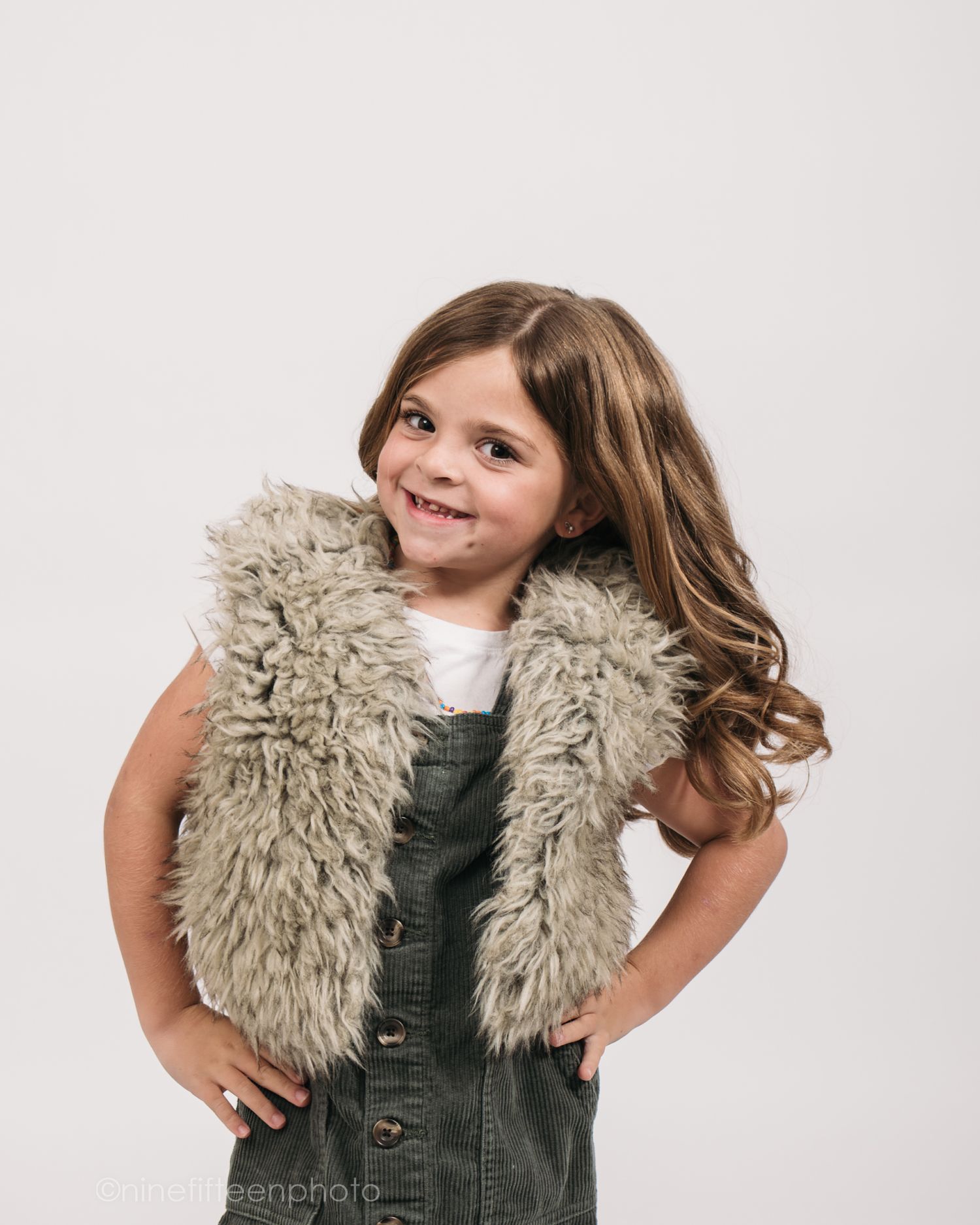 Studio personality portrait of a young girl spinning with movement and flowing hair against a neutral background in Meade County KY