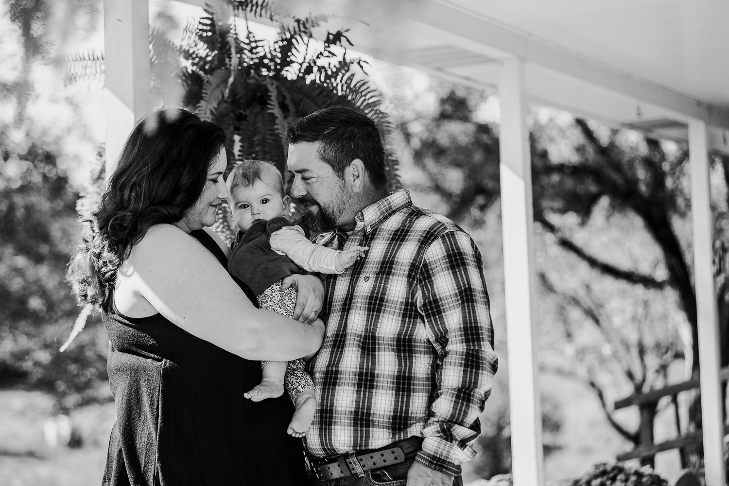 Timeless black and white family portrait on the farmhouse porch in Battletown KY captured by ninefifteenphoto