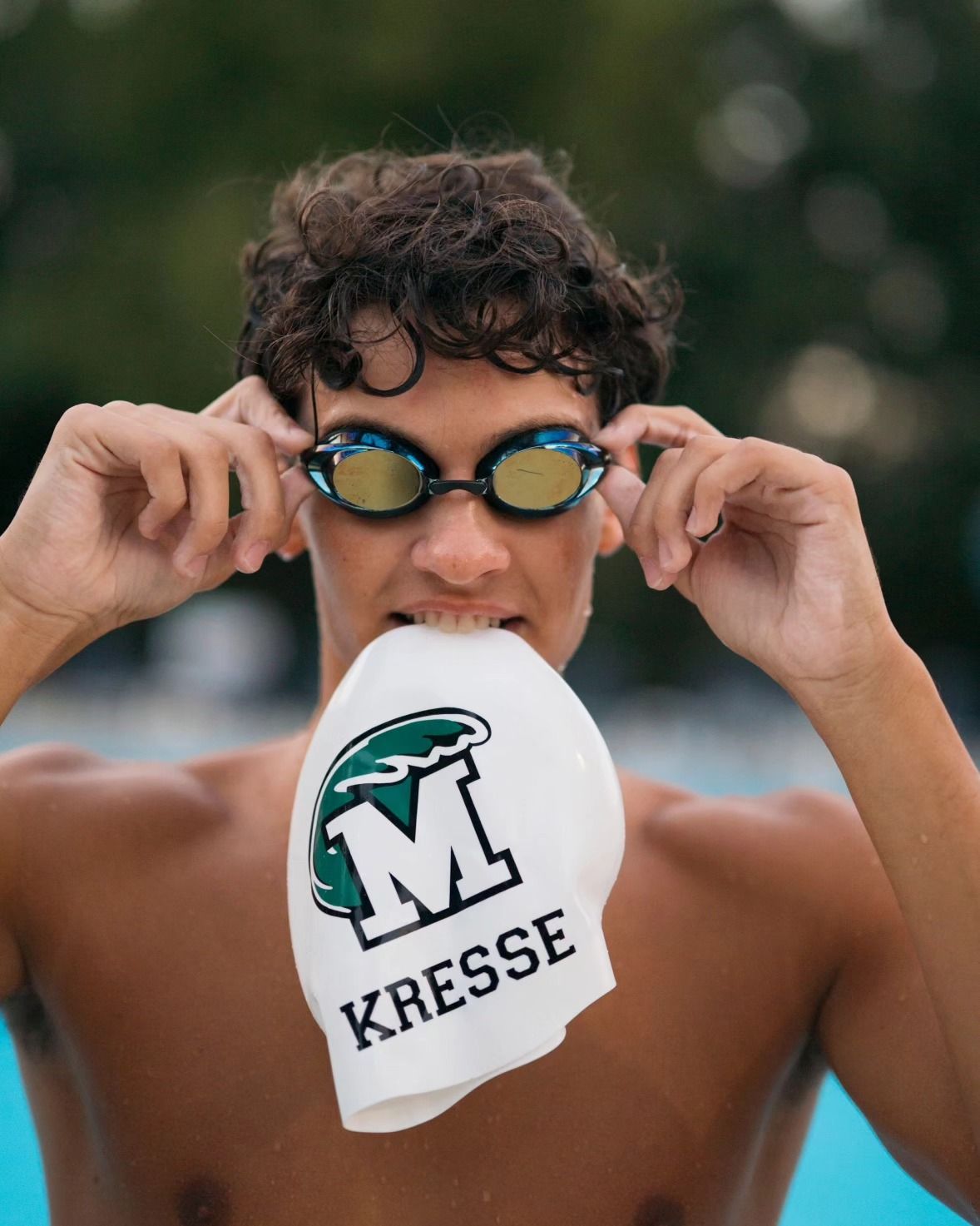 senior during his photoshoot with his swim cap and googles.