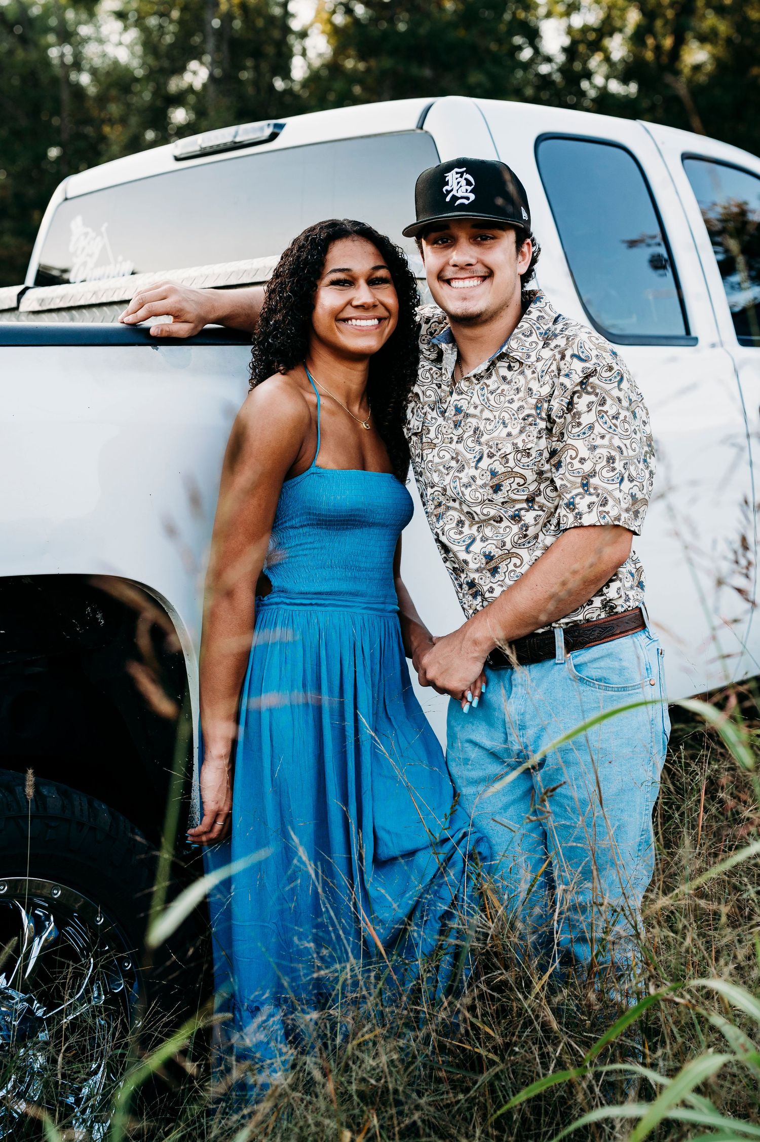 Bella and her boyfriend smiling by white truck during country senior session in Brandenburg Kentucky by ninefifteenphoto