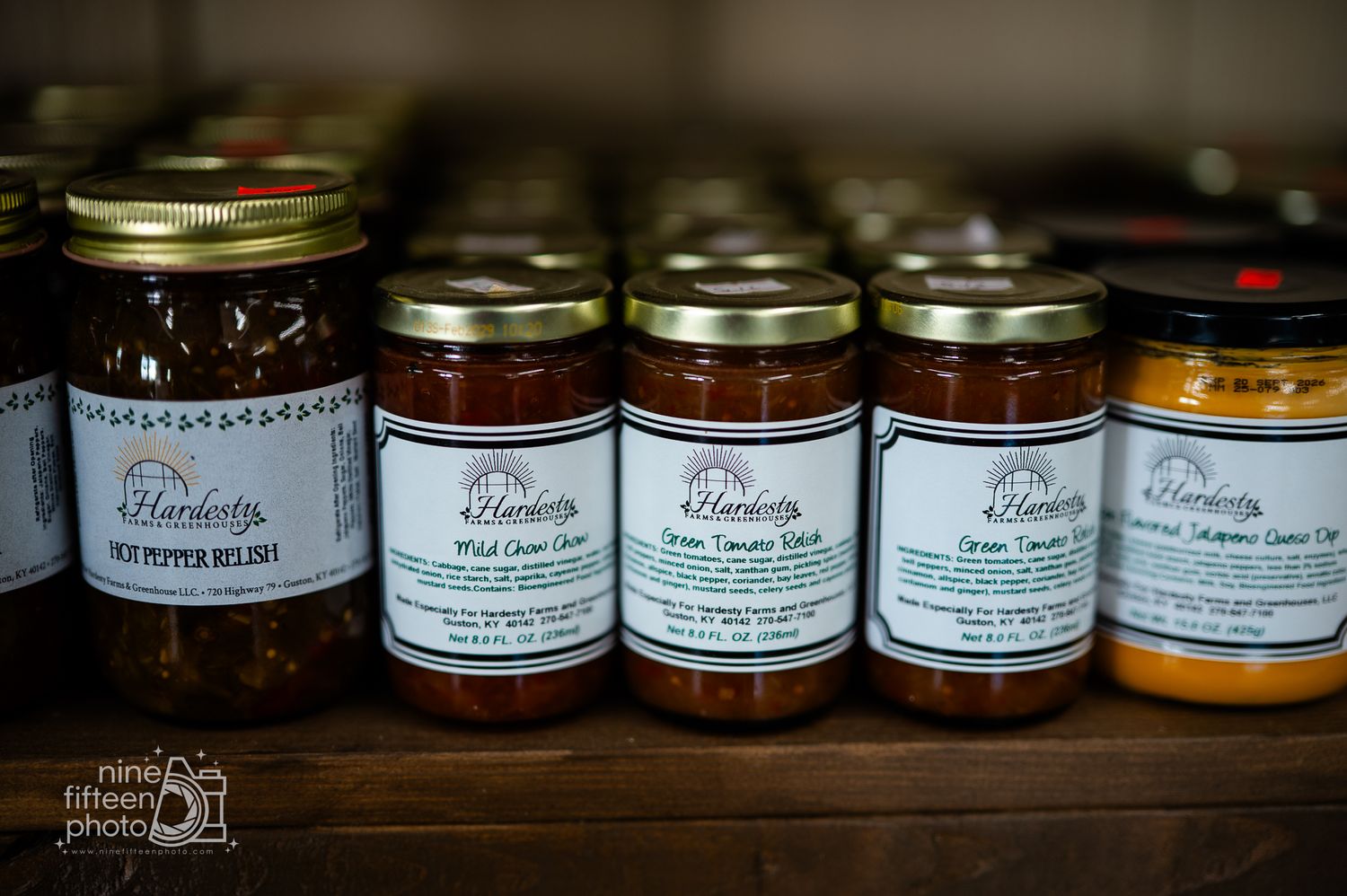 Rows of Hardesty-branded jarred relishes and pepper sauces on a wooden store shelf.
