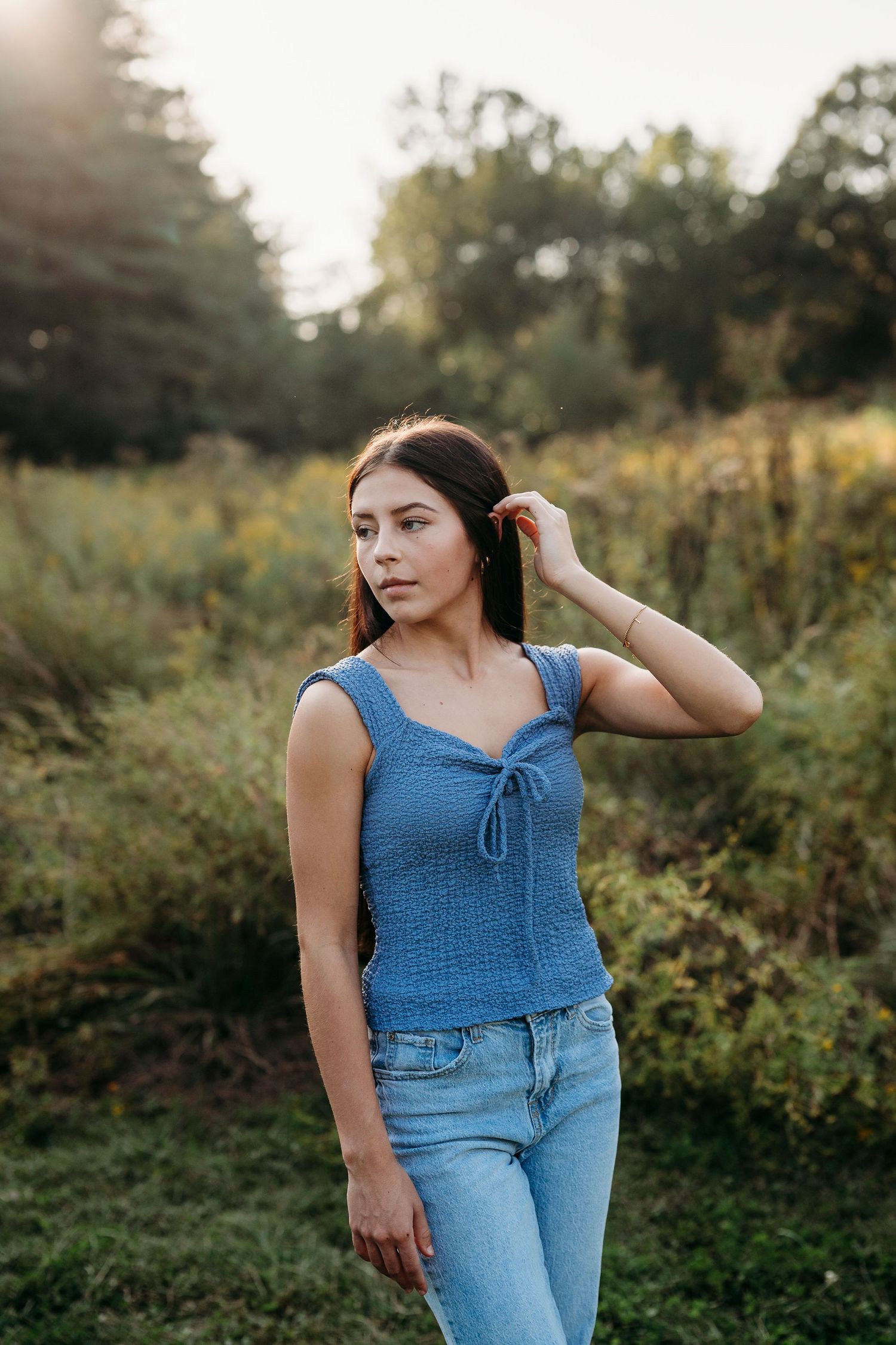 Emily standing in a field at Otter Creek Park in Brandenburg KY during her senior session with ninefifteenphoto.