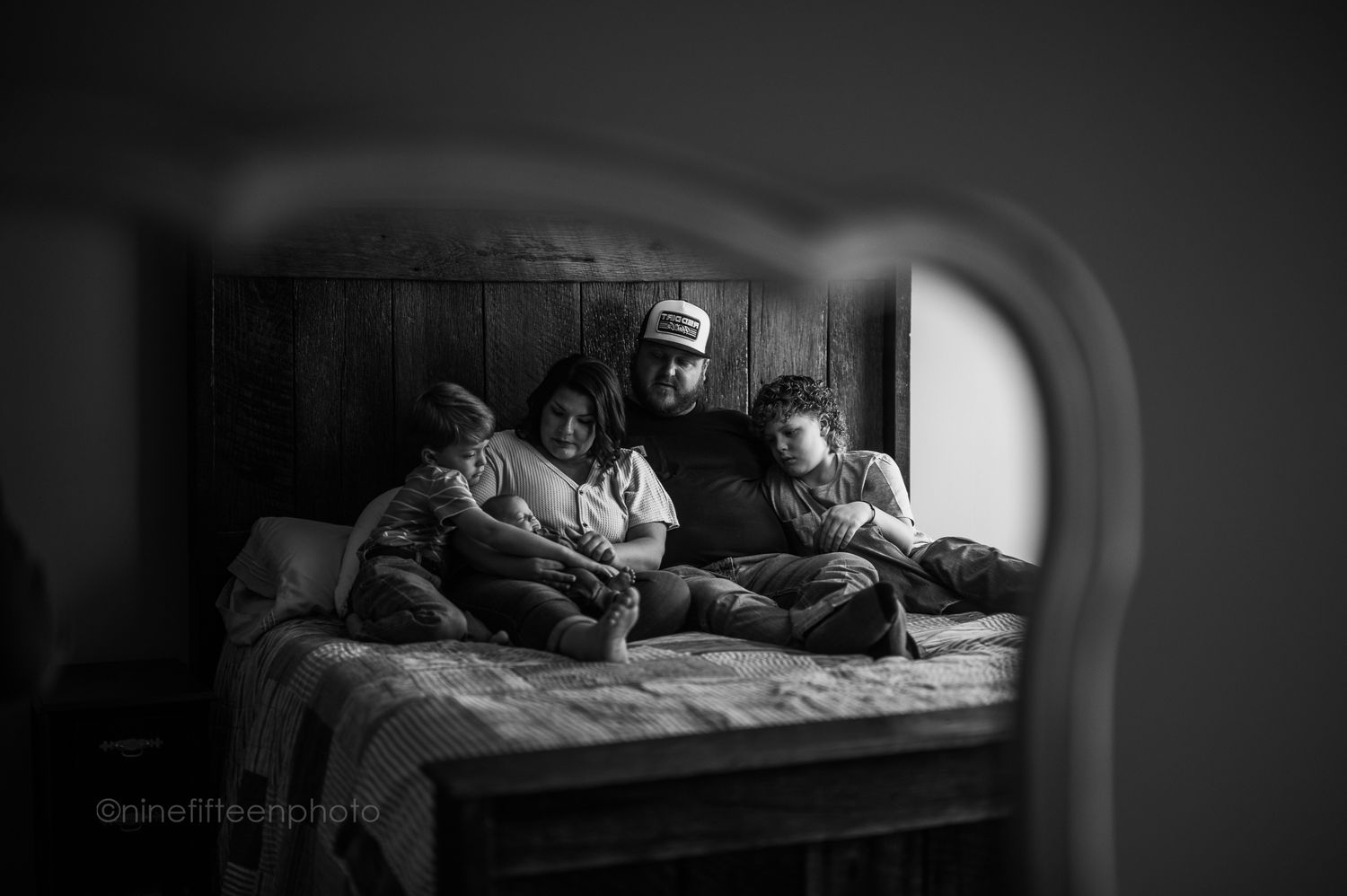Black and white family cuddles on bed, ninefifteenphoto Brandenburg KY lifestyle family photographer in Meade County.