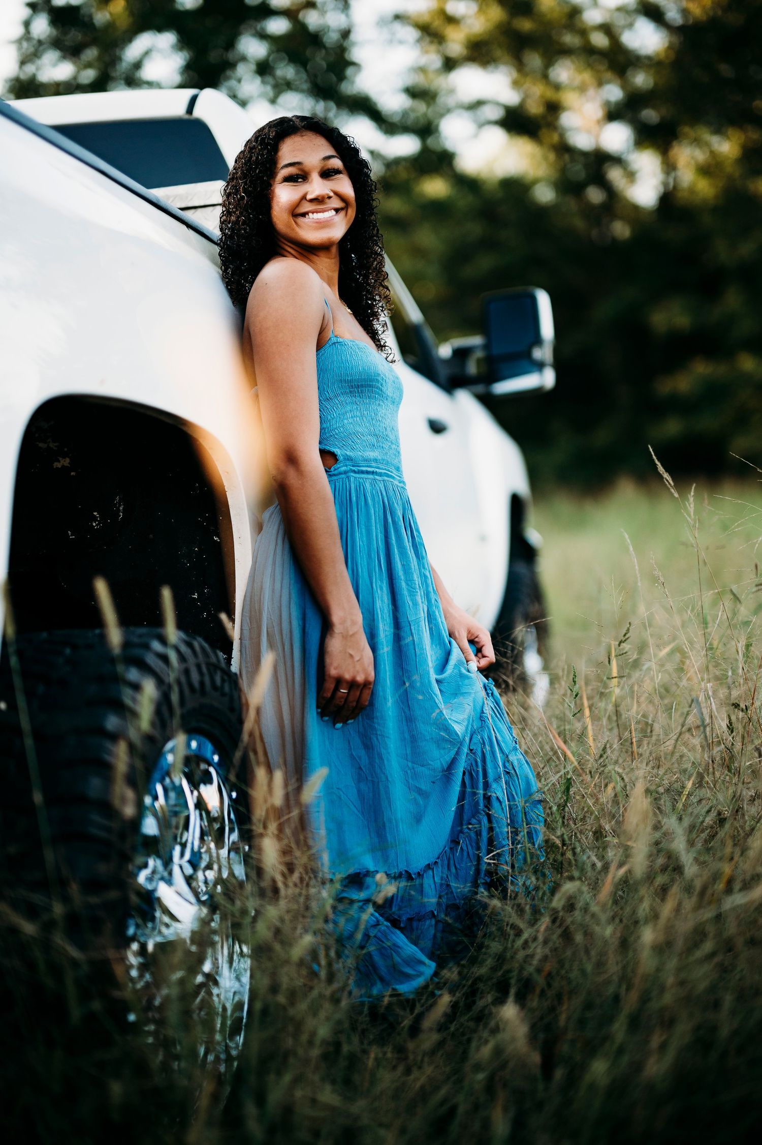 Bella leaning on white truck in field during Brandenburg Kentucky senior photos by ninefifteenphoto
